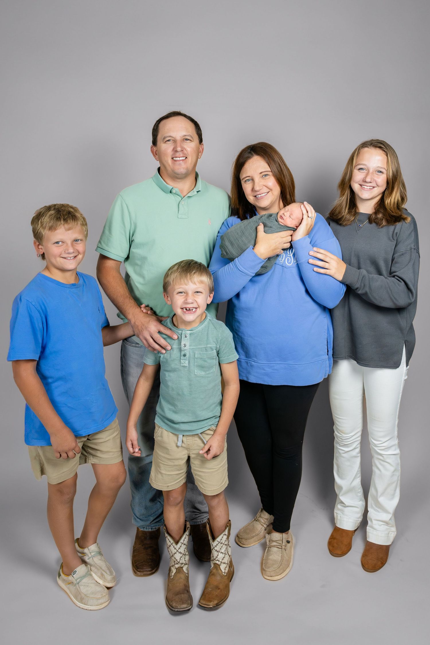 Family photo series showing group poses in coordinated blue and grey casual outfits.