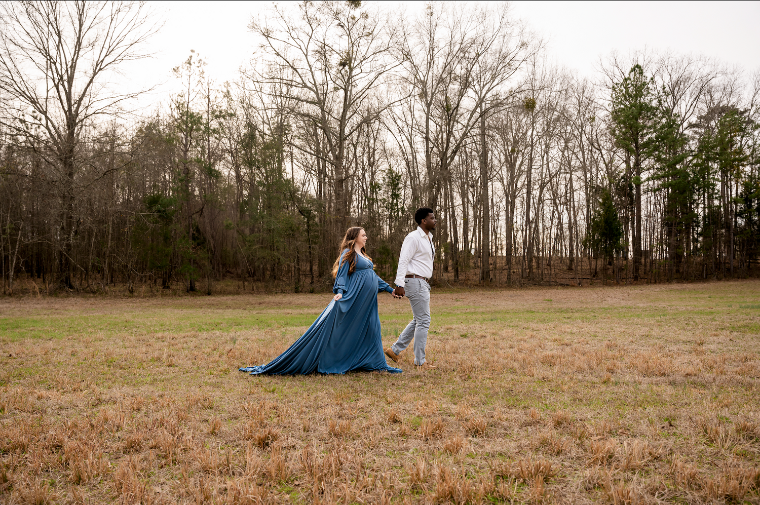 Blue blanket spread out in grassy field during golden hour.