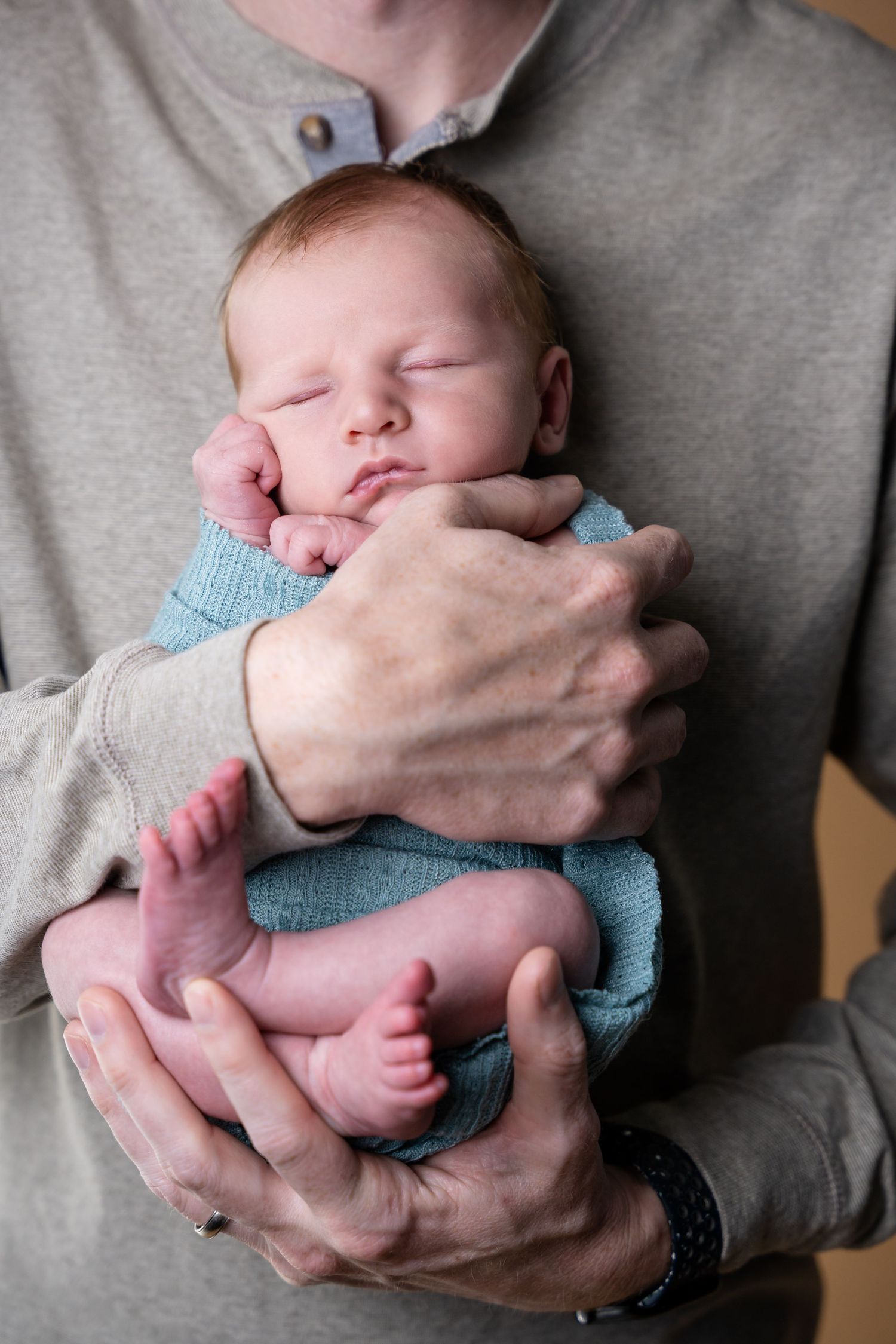 Professional newborn photography showing a sleeping baby being gently cradled in hands in multiple poses.