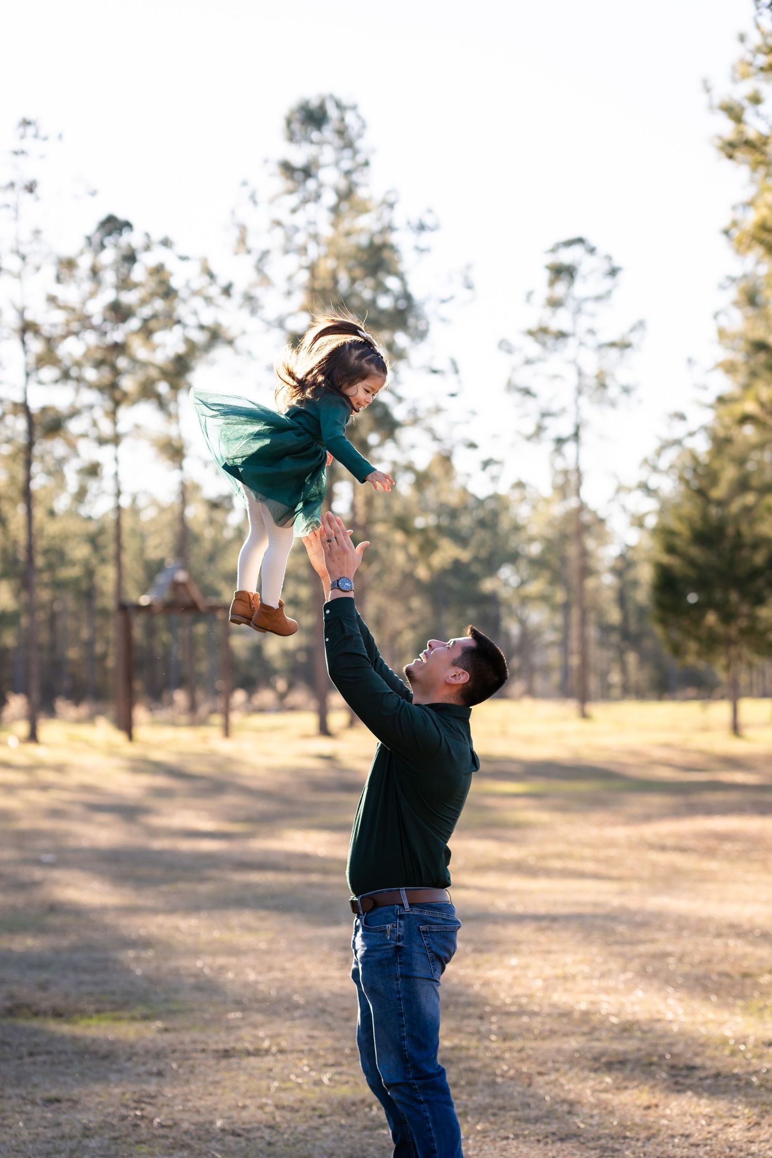 Joyful moments captured as family members play together in a sunny outdoor setting.
