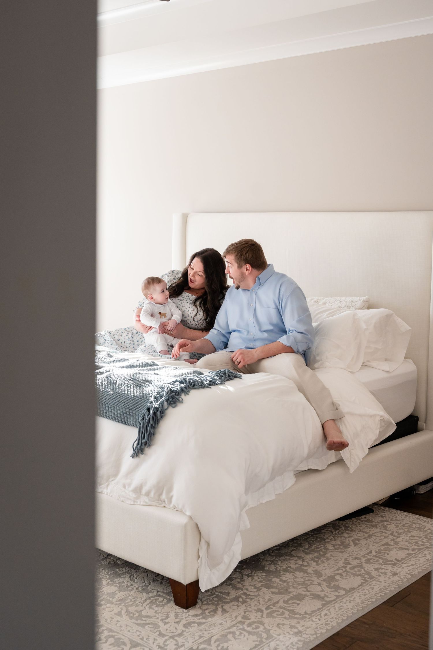 Lifestyle family photography session with relaxed poses on a white bed.