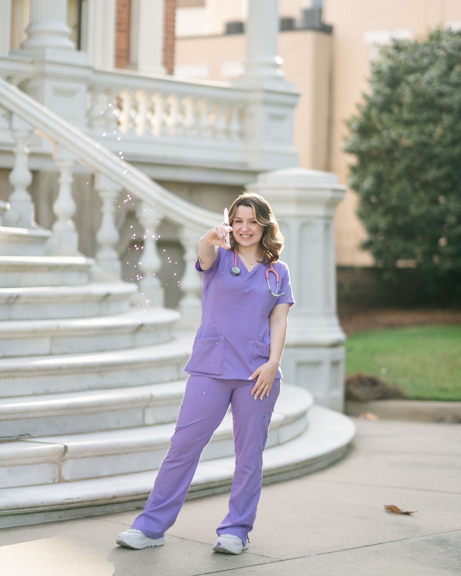Figure in purple medical scrubs posing on white marble steps with classical architectural details.