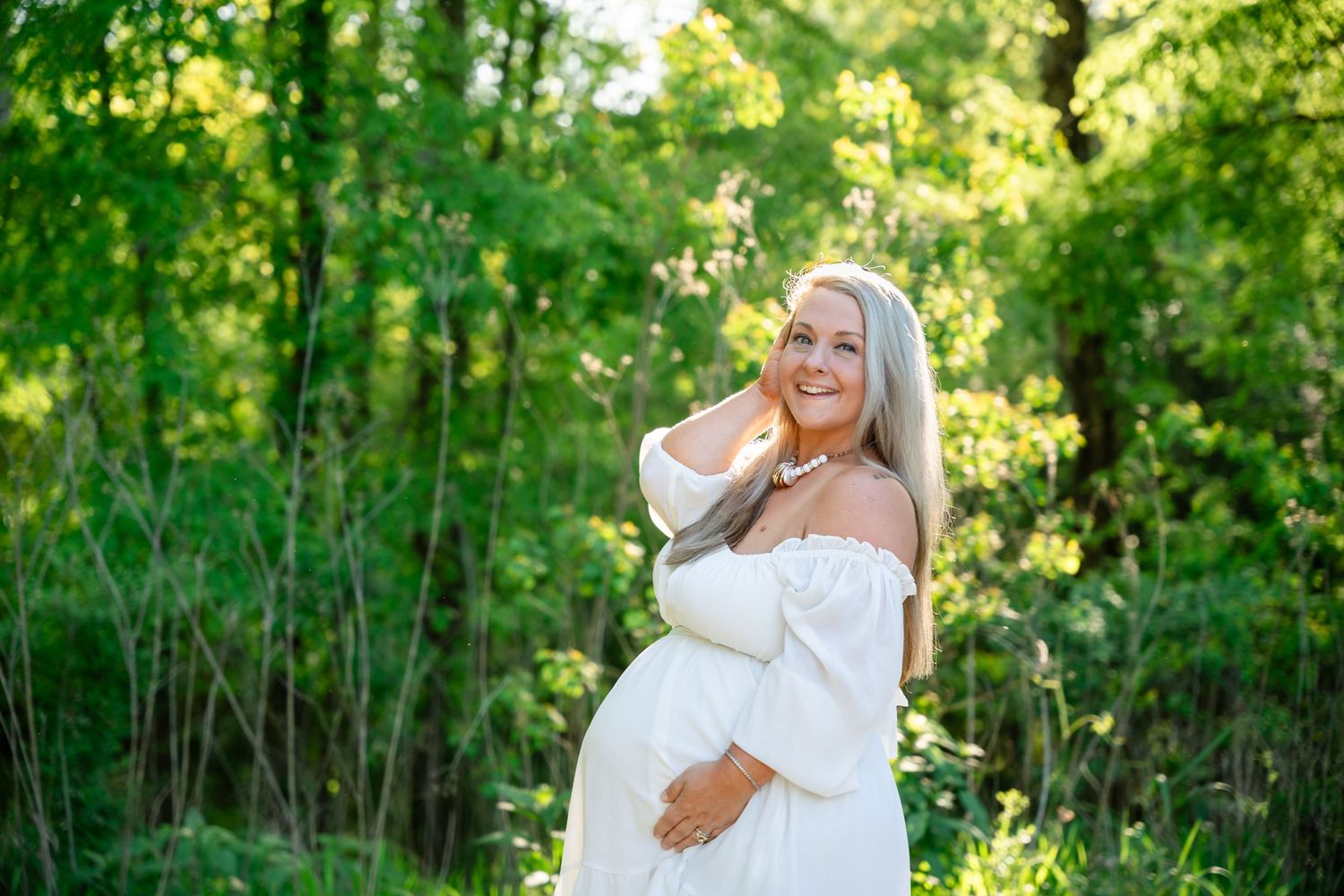 Outdoor summer photoshoot in a lush green wooded area with natural lighting.