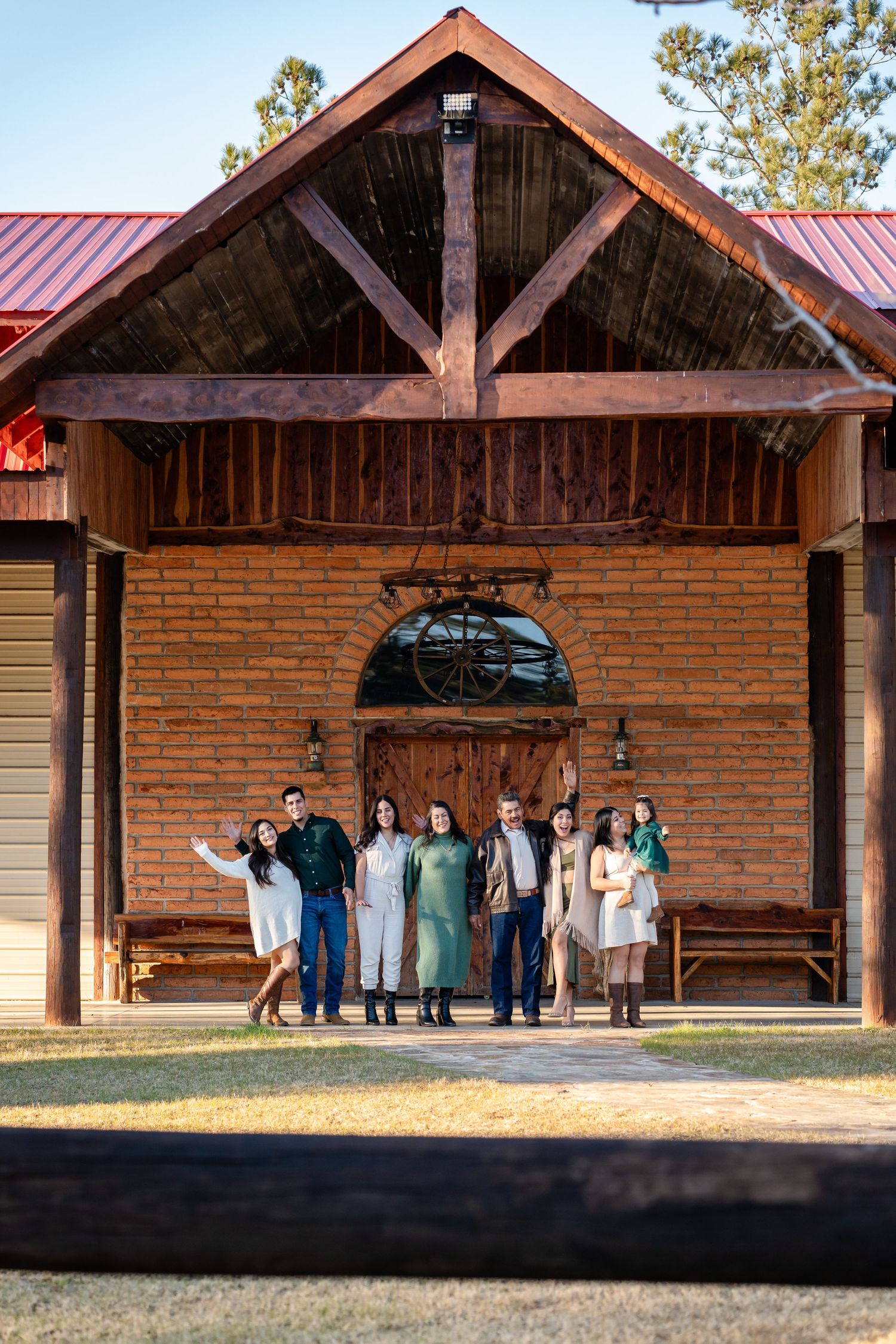 Rustic brick building with wooden beams serves as backdrop for outdoor photo session.