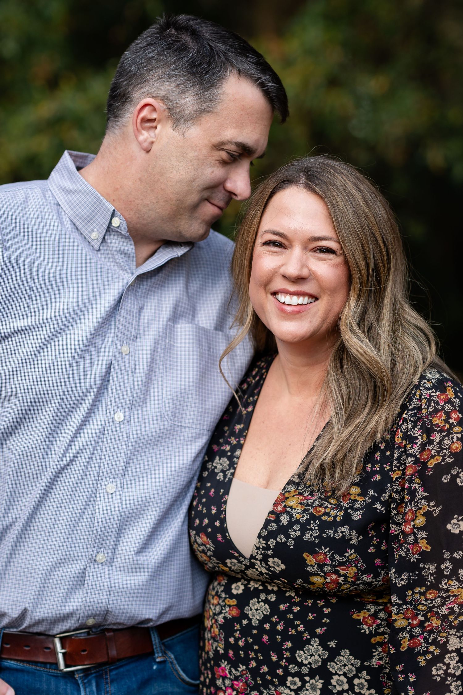 Couple shares intimate moments and laughter during outdoor fall photo session.