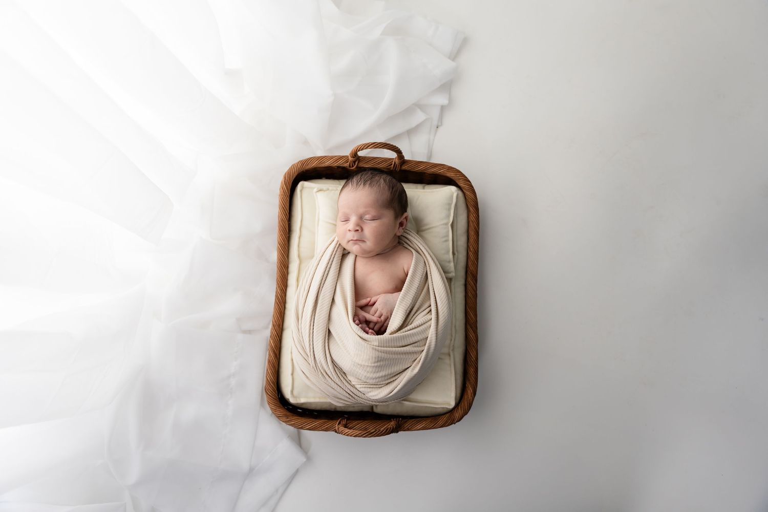Series of minimalist newborn photos with baby sleeping in wooden frame prop.