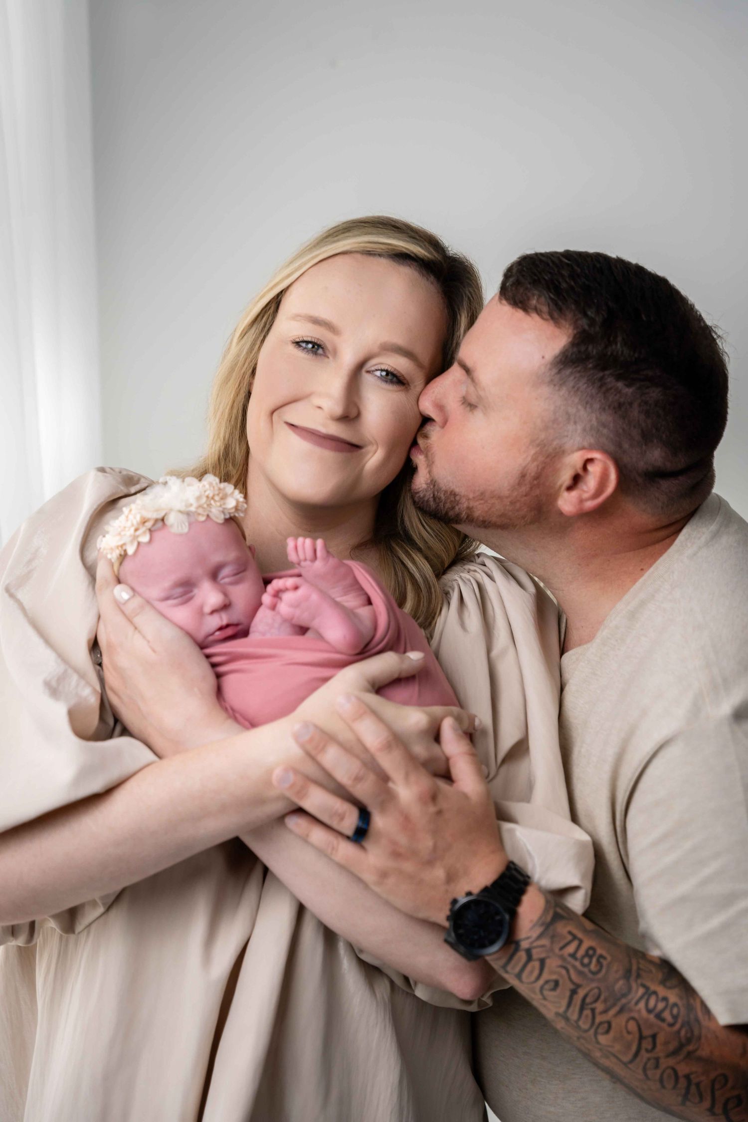 Intimate newborn photography session featuring tender family moments on white background.