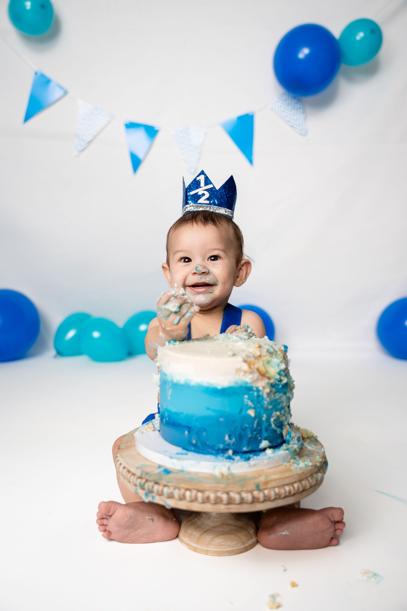 Blue ombre cake smash setup with balloons and bunting decorations.