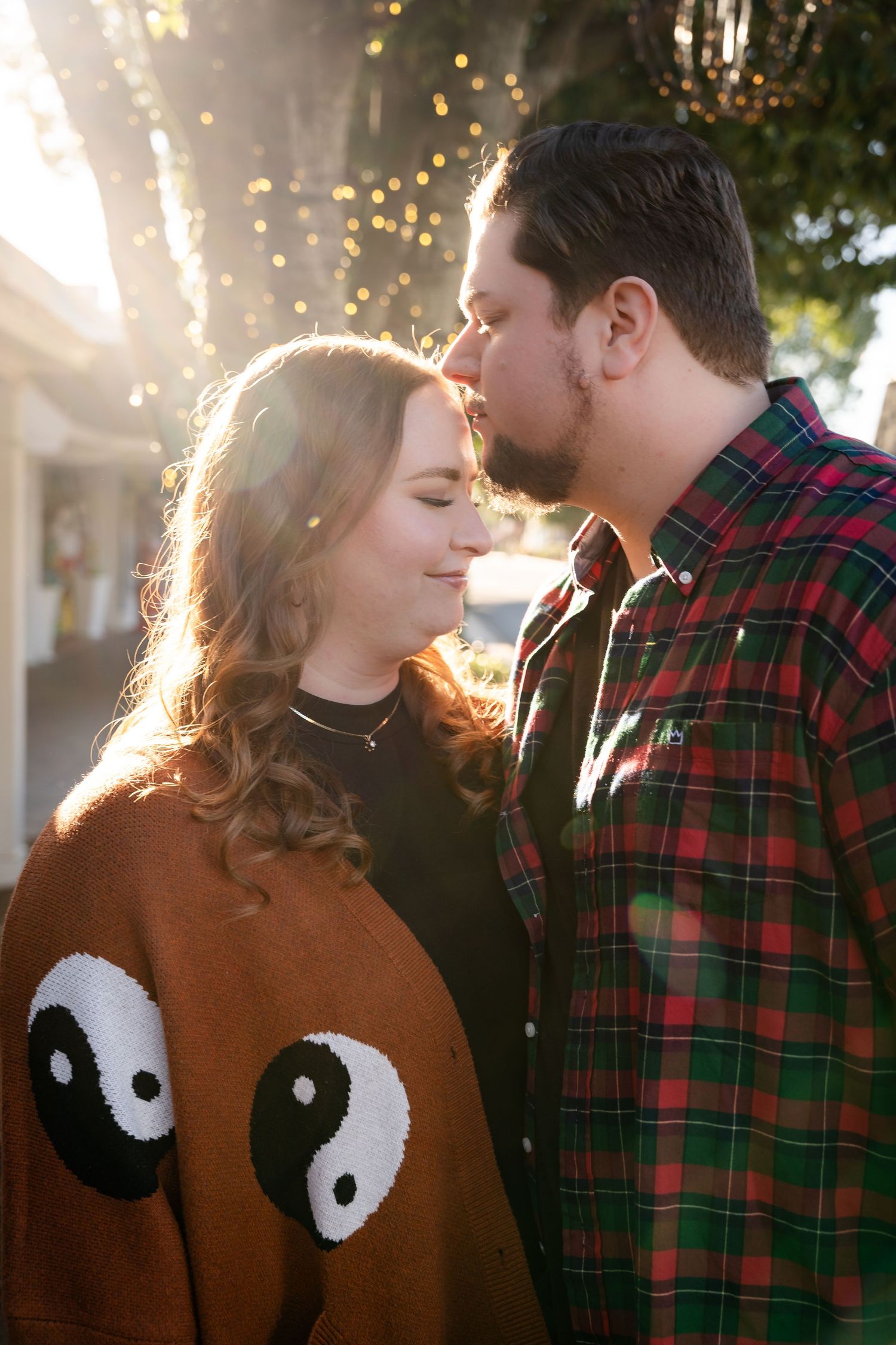Close-up of couple in sunlit setting with yin-yang sweater detail.