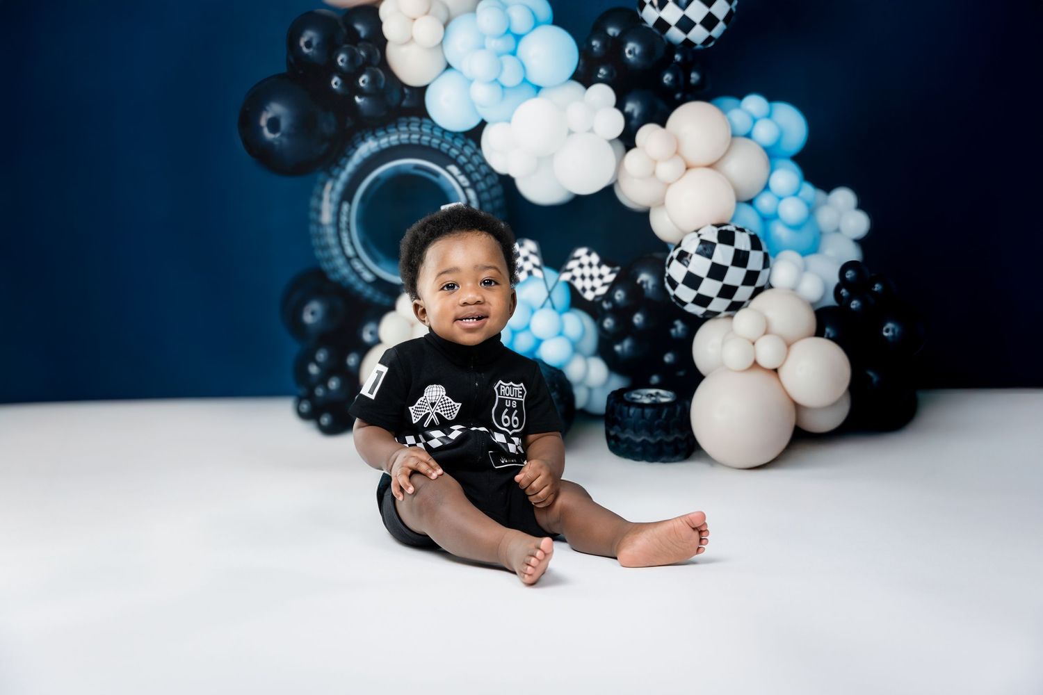 Modern photo setup with blue and white balloon arch against dark background.