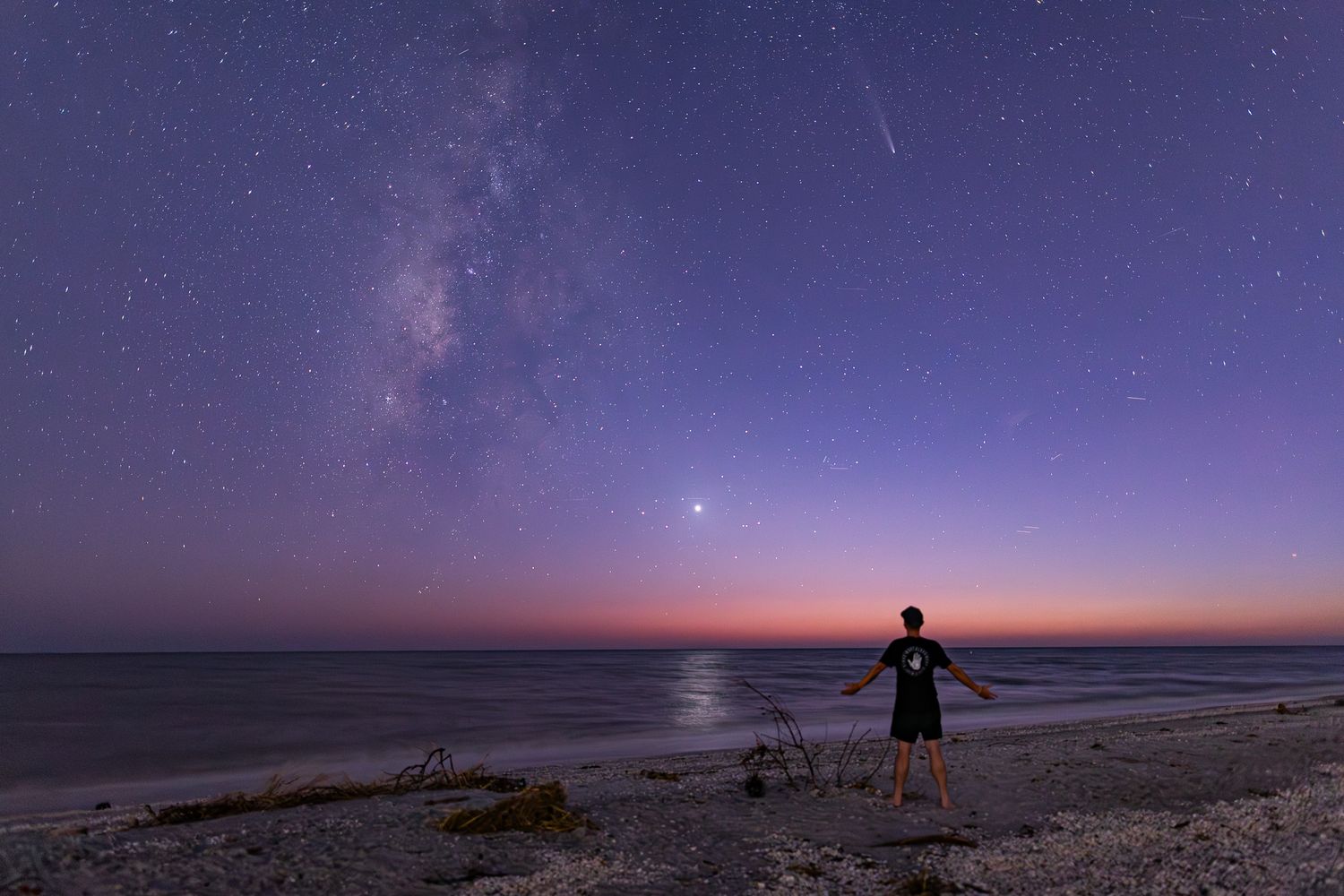 A stunning timelapse sequence of a purple and orange sunset transitioning to a starry night sky over a desert landscape.