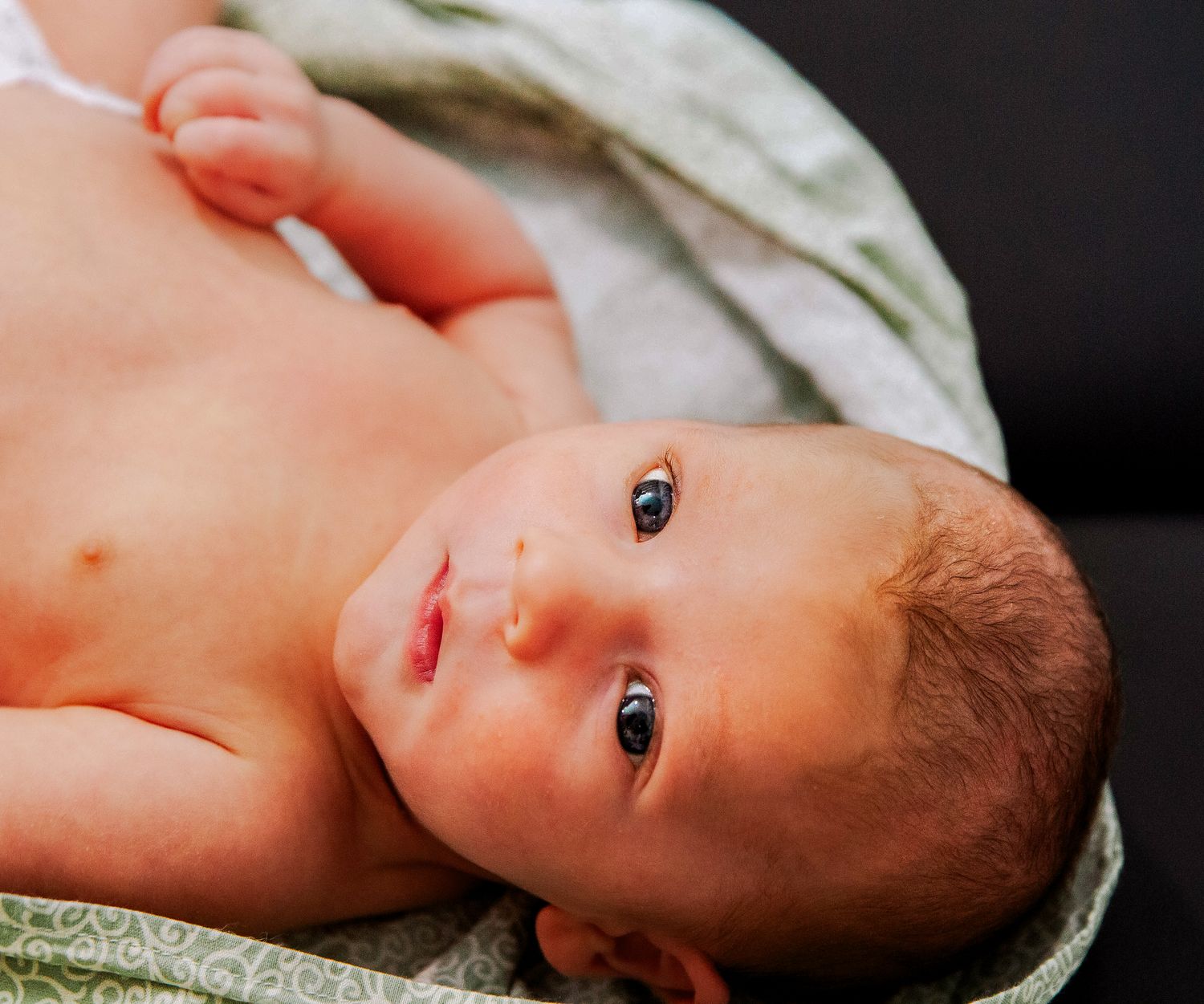 Newborn about to get weighed at postpartum appointment with midwife in Decatur