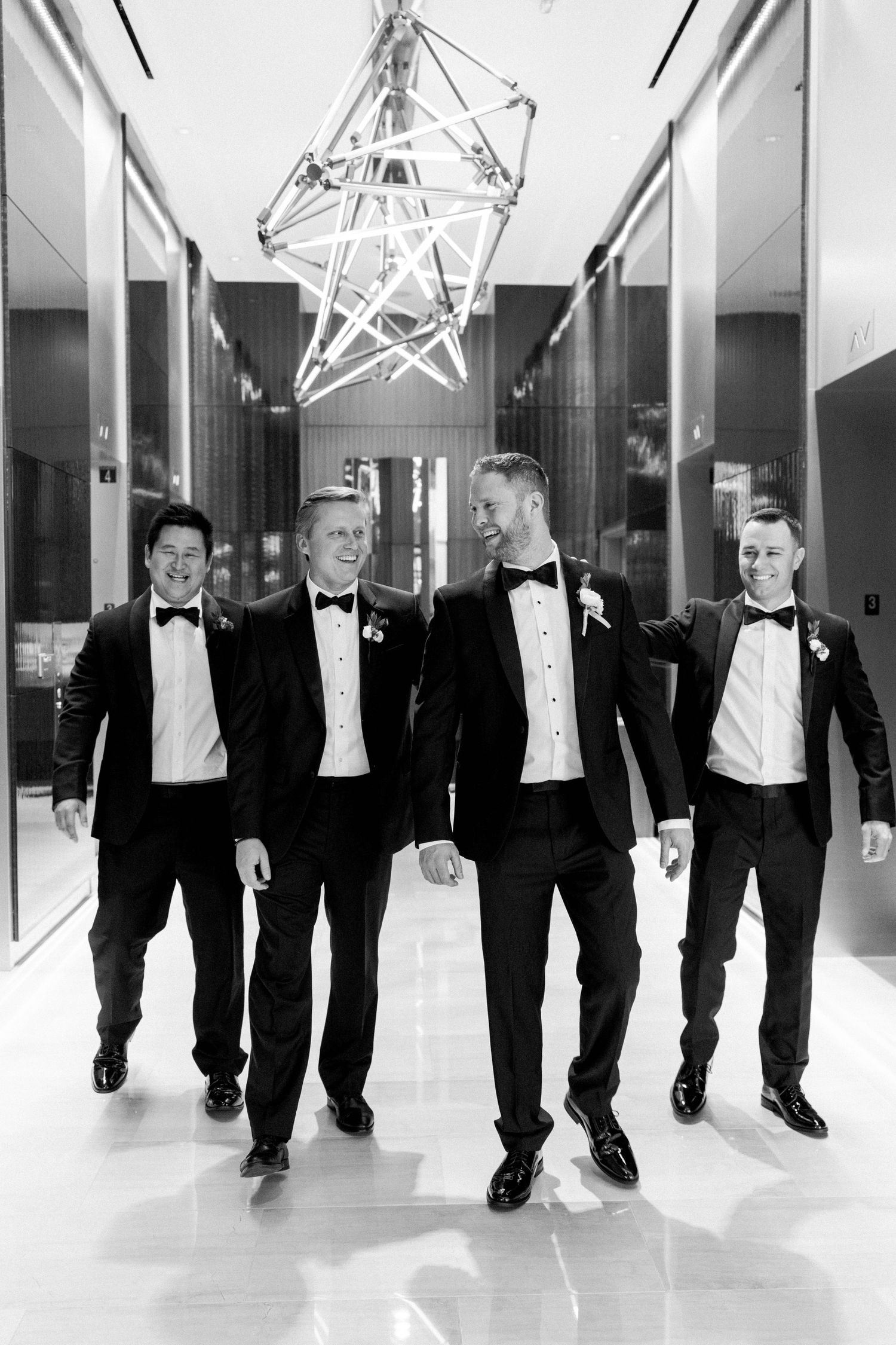 The groom and groomsmen talking and walking inside the hotel.