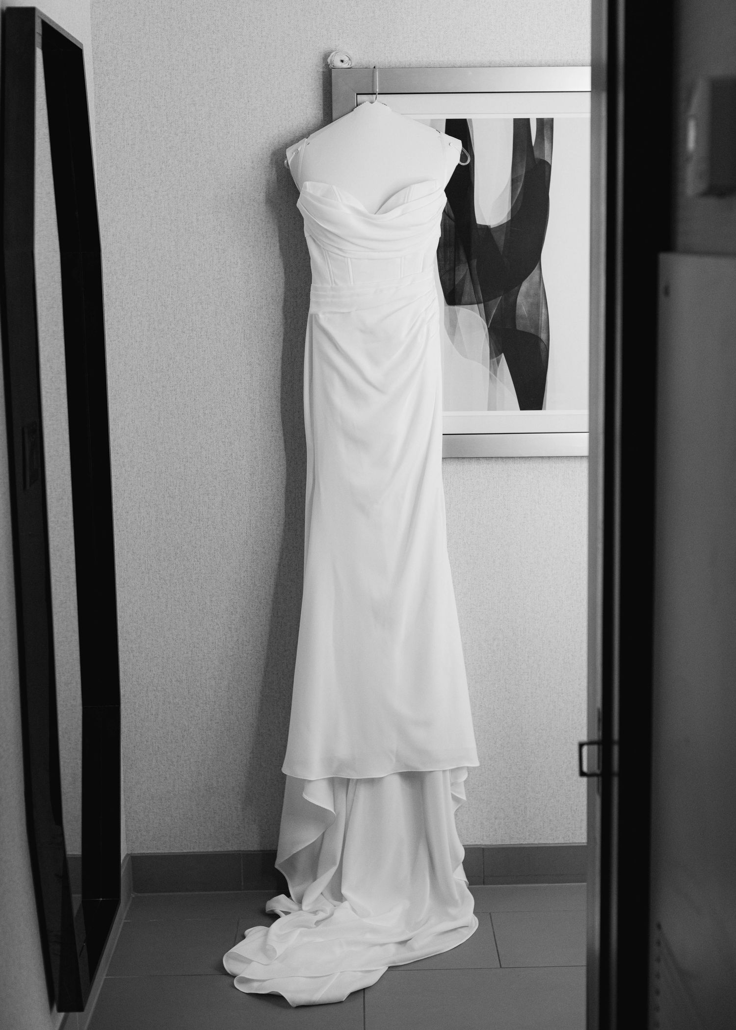 Portrait of bride's gown hanging inside a Hyatt Regency Hotel room.