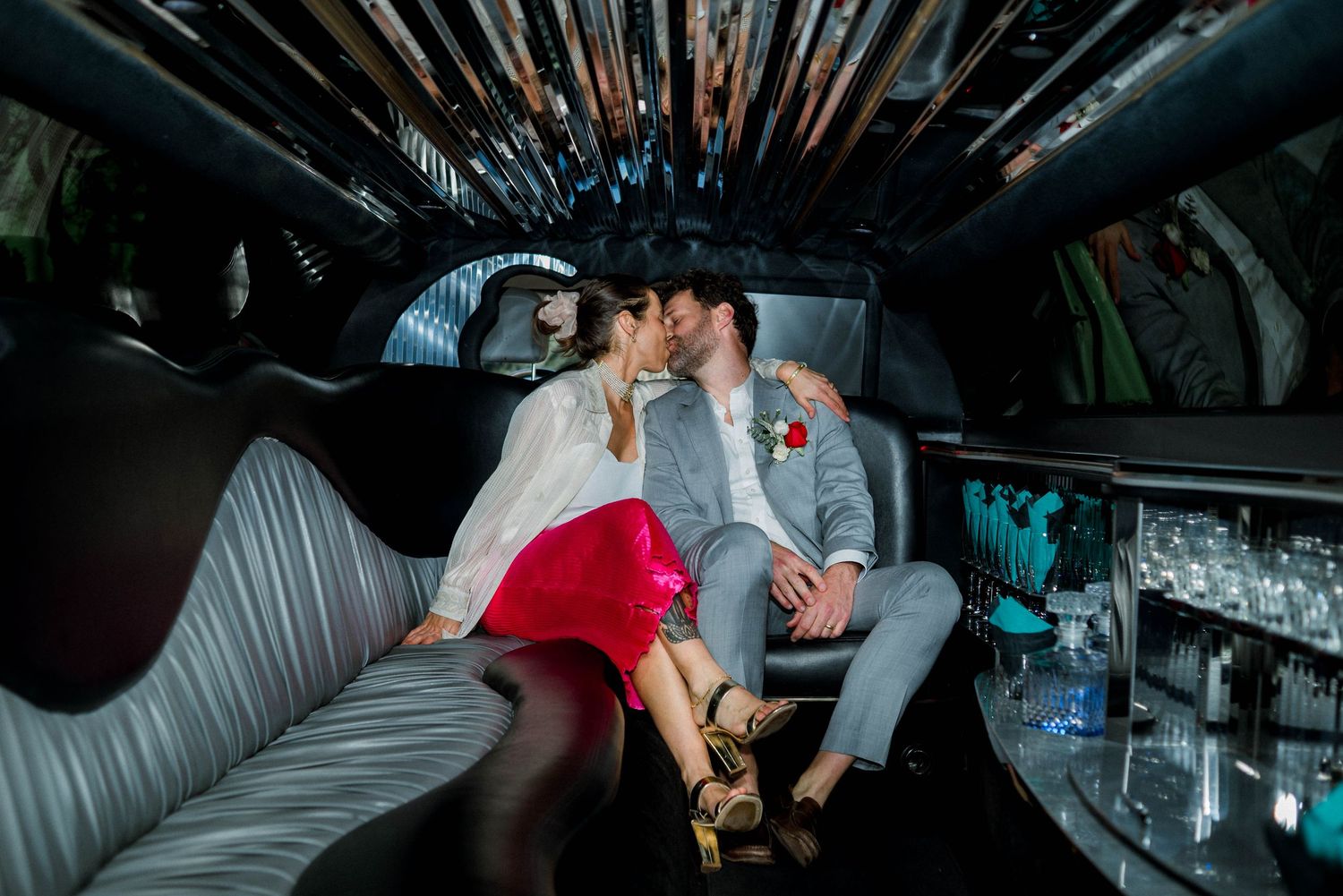 Bride and groom kissing in limo.