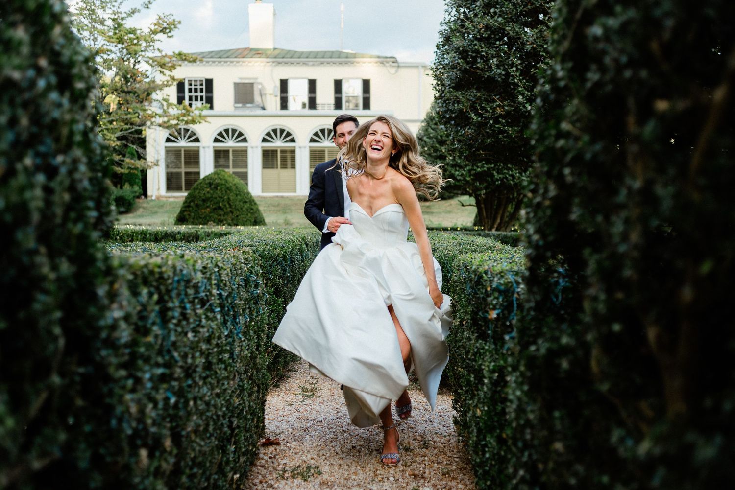 Couple running through the boxwood garden- Airlie, Warrenton, Virginia