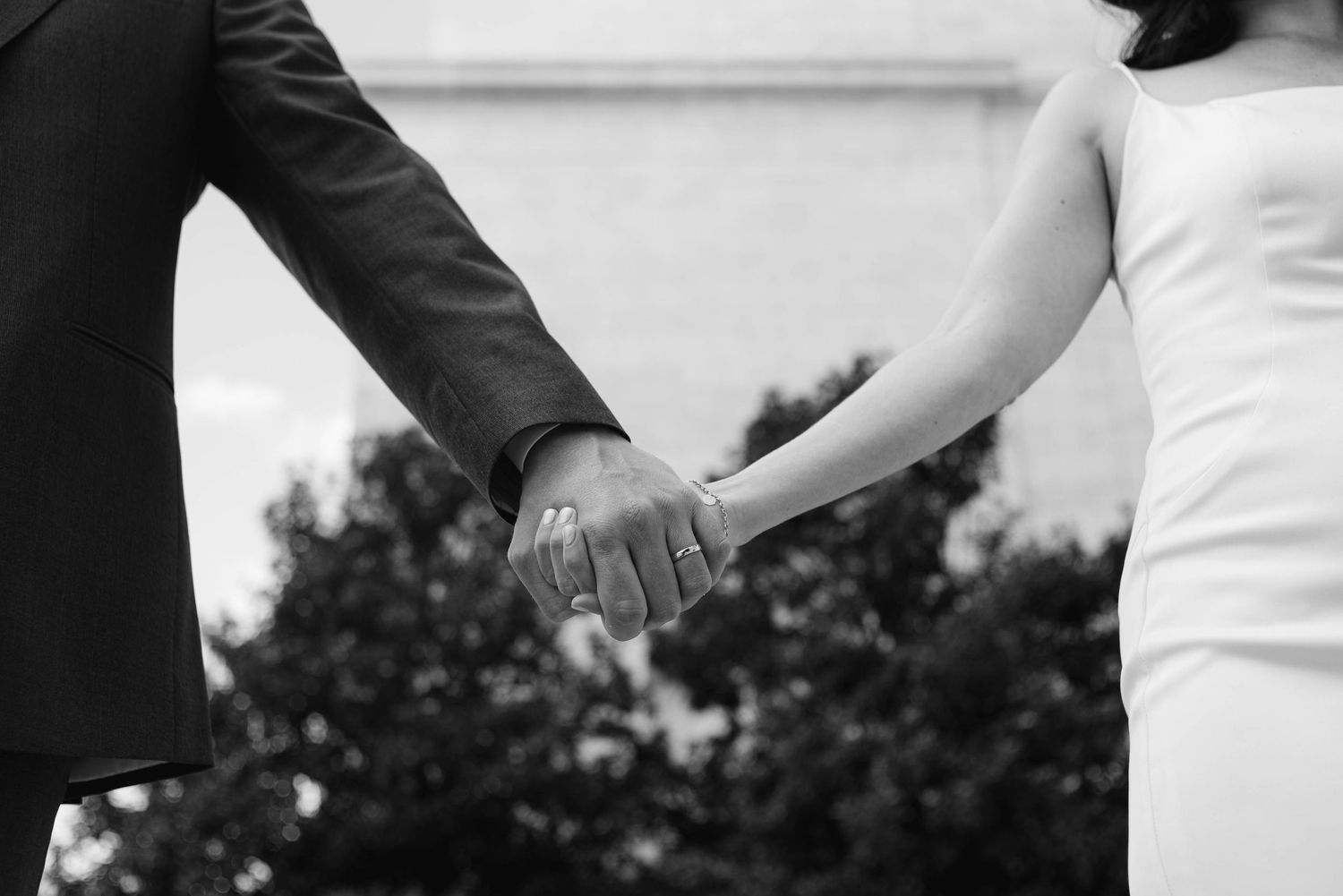 A couple holding hands in front of a historic building in DC.