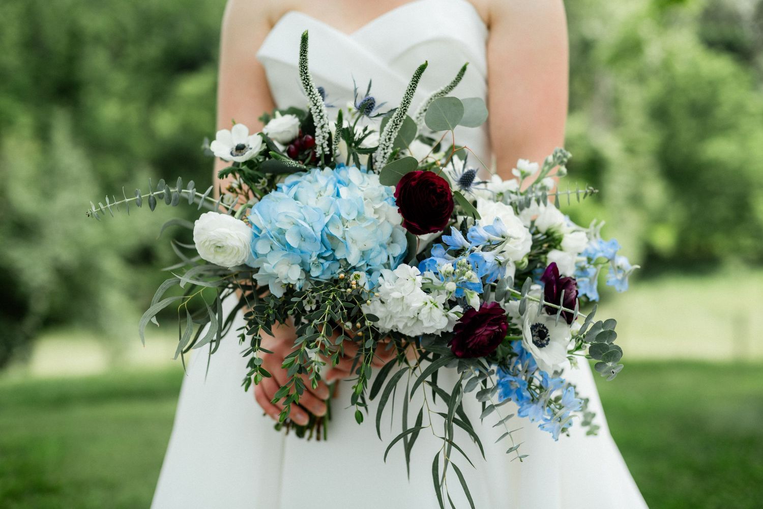 Bride holding a lovely floral bouquet in front of her at Old Farm Winery at Hartland in Aldie, Virginia
