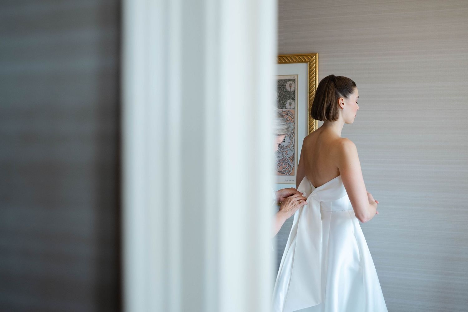 Mom helping bride get into wedding dress at The Omni Shoreham Hotel in DC