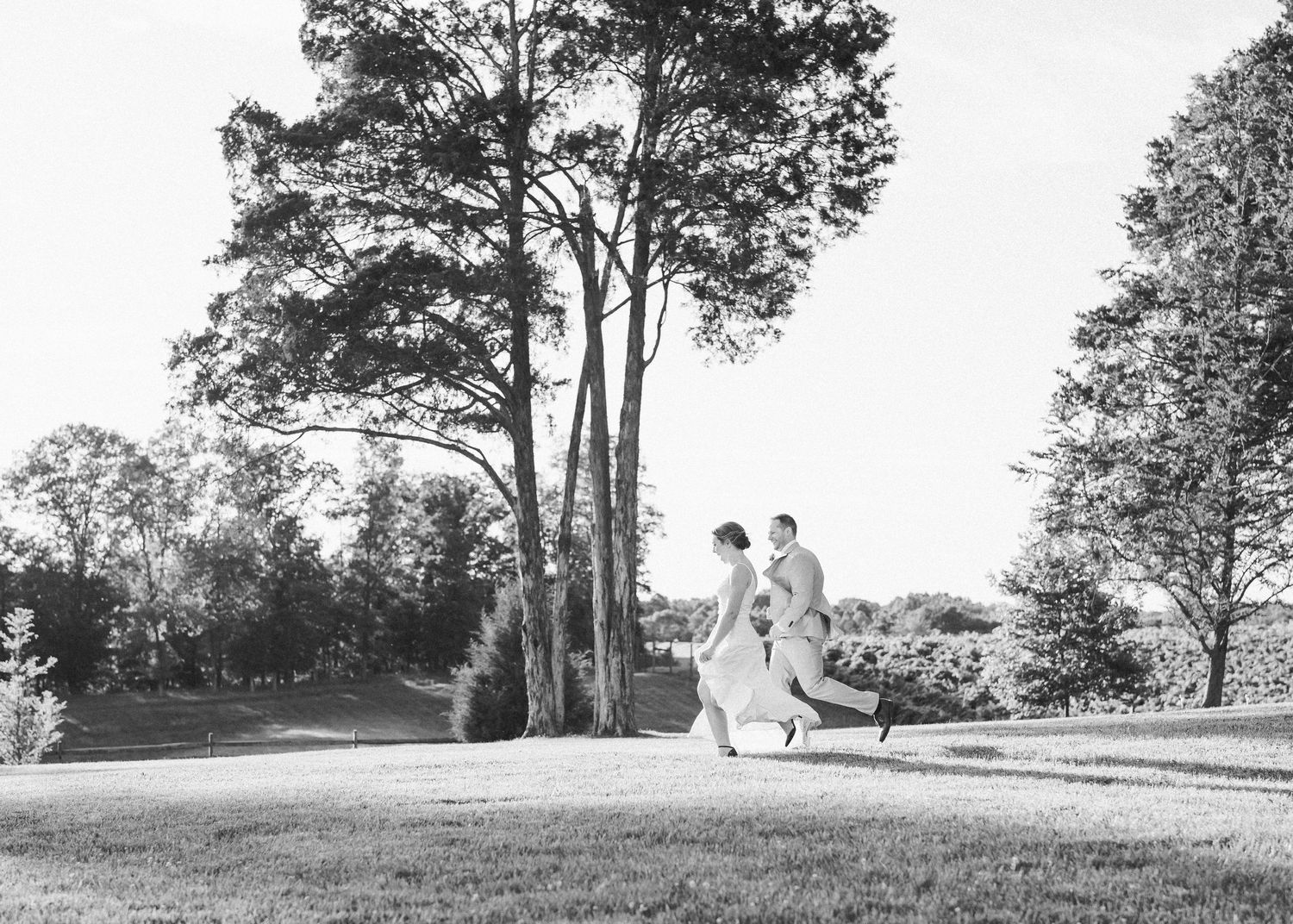 Couple running through The Winery at Bull Run fields