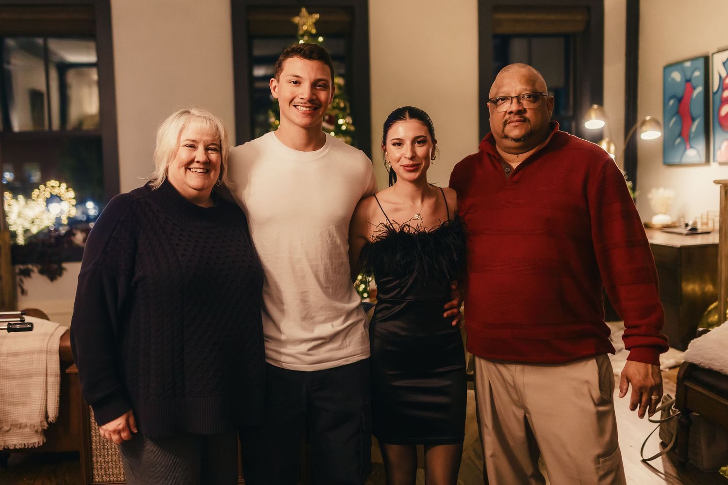 A group of people gathered together in a cozy indoor setting during what appears to be a holiday celebration.