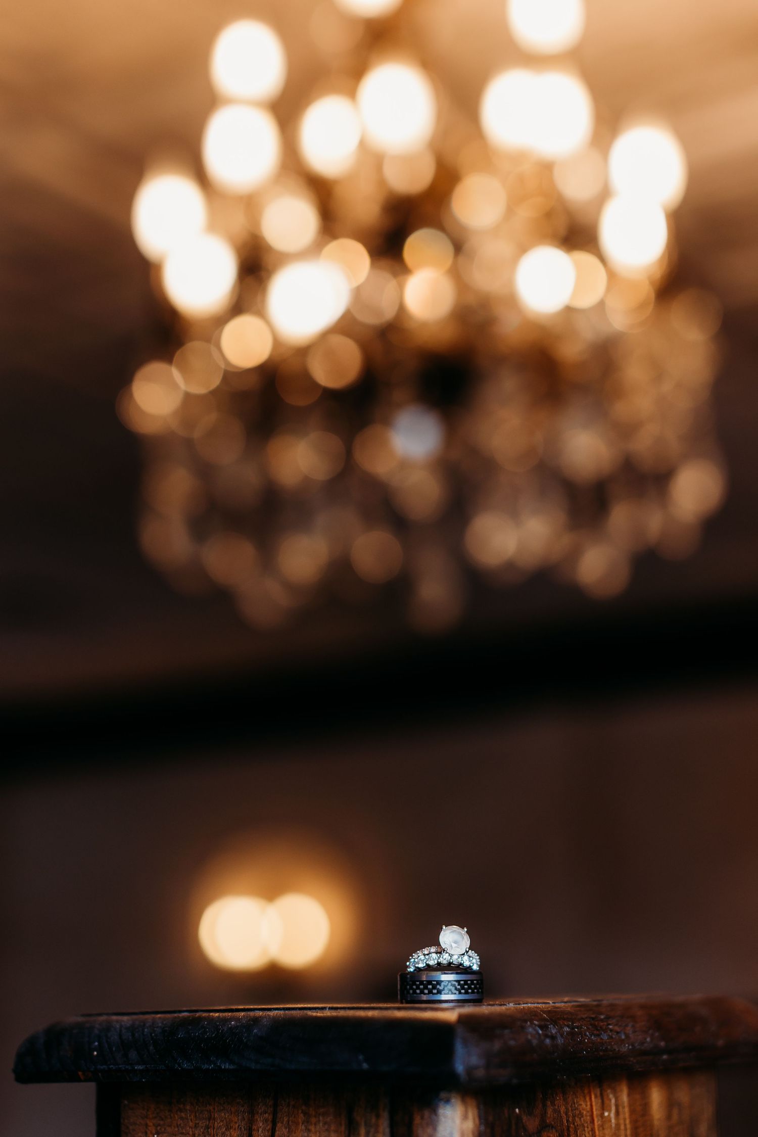 Wedding rings photographed with bokeh lights creating romantic atmosphere.