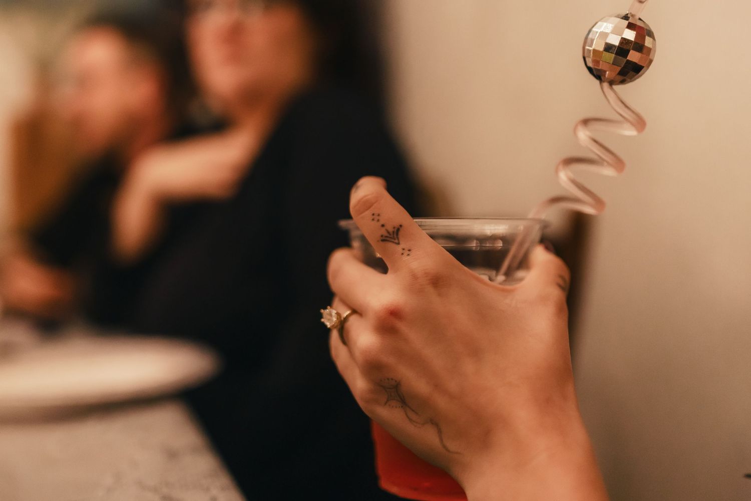 Several wine glasses held up in a toast against a warm, blurred background.