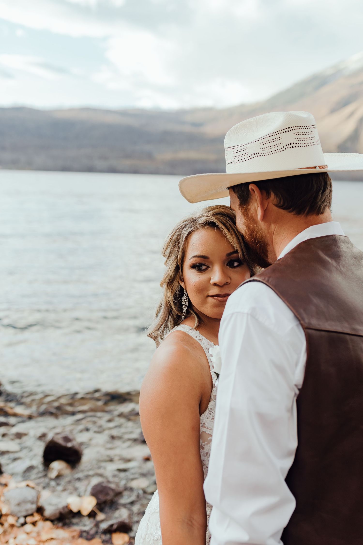 An intimate wedding moment captured against a stunning mountain lake backdrop.