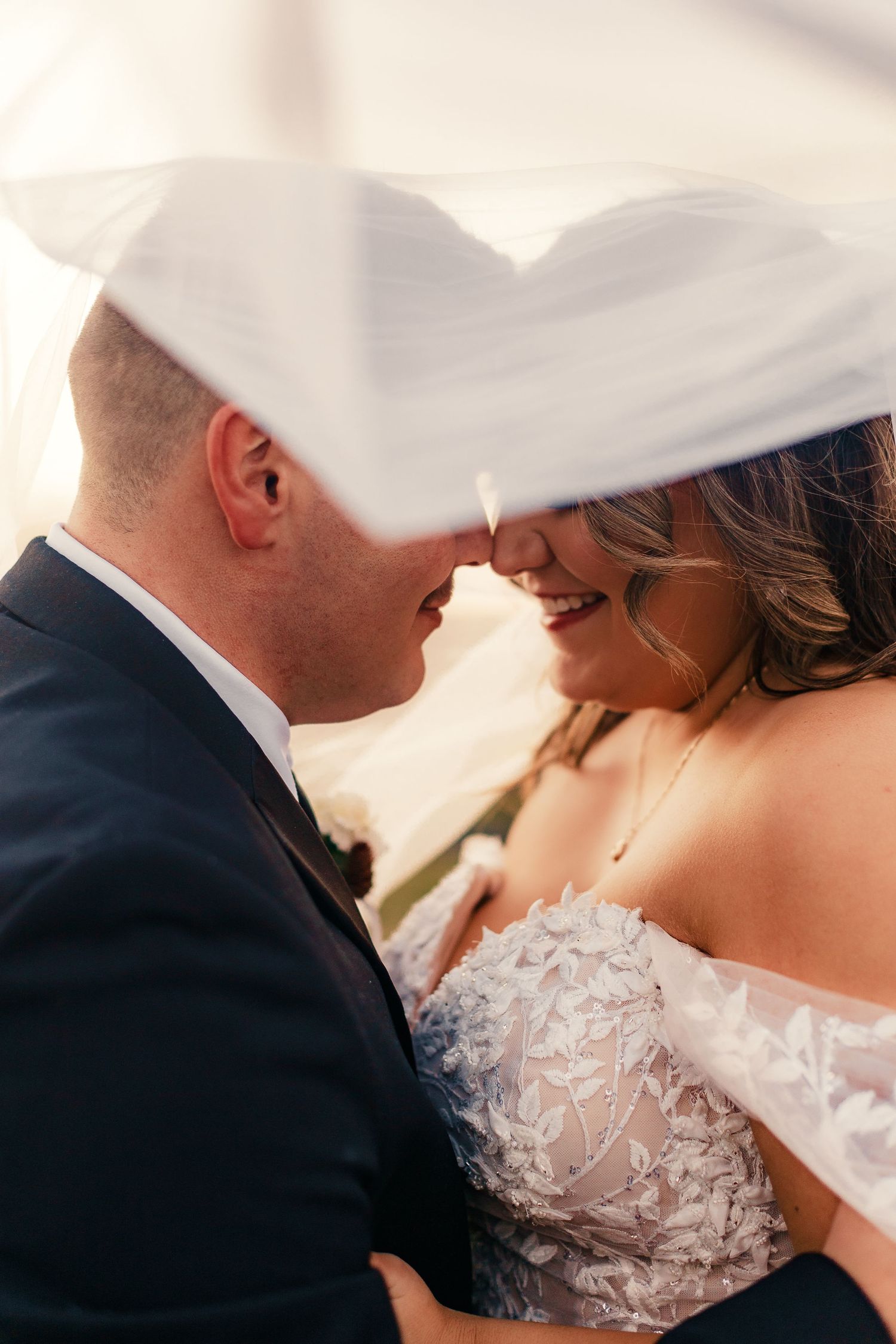 Romantic close-up of couple in wedding attire sharing an intimate moment.