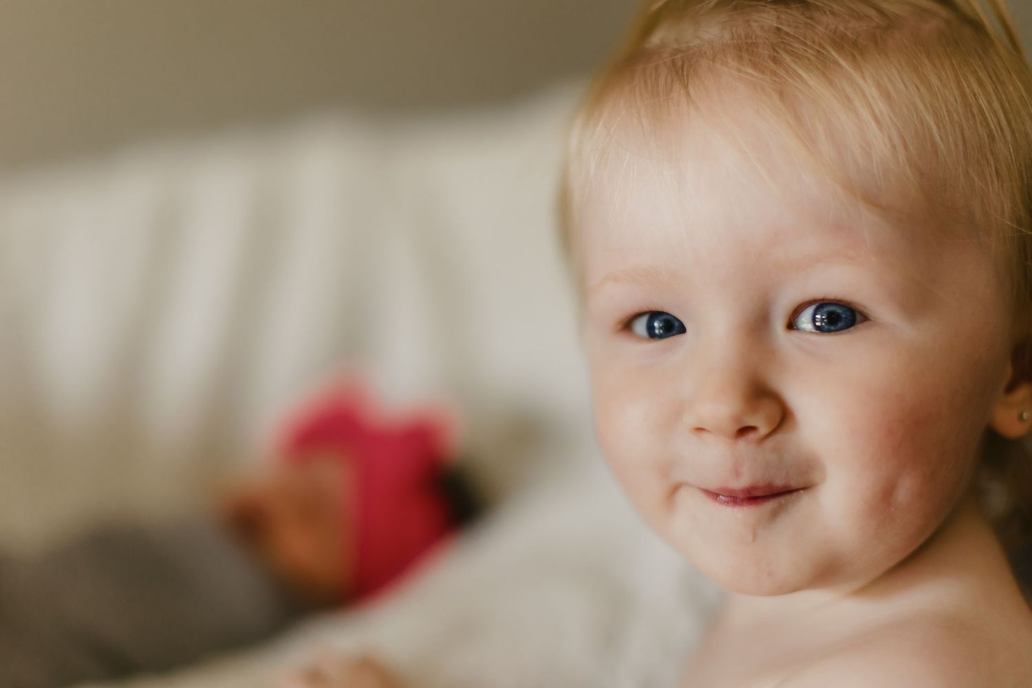 Close up portrait of a smiling toddler with bright eyes.