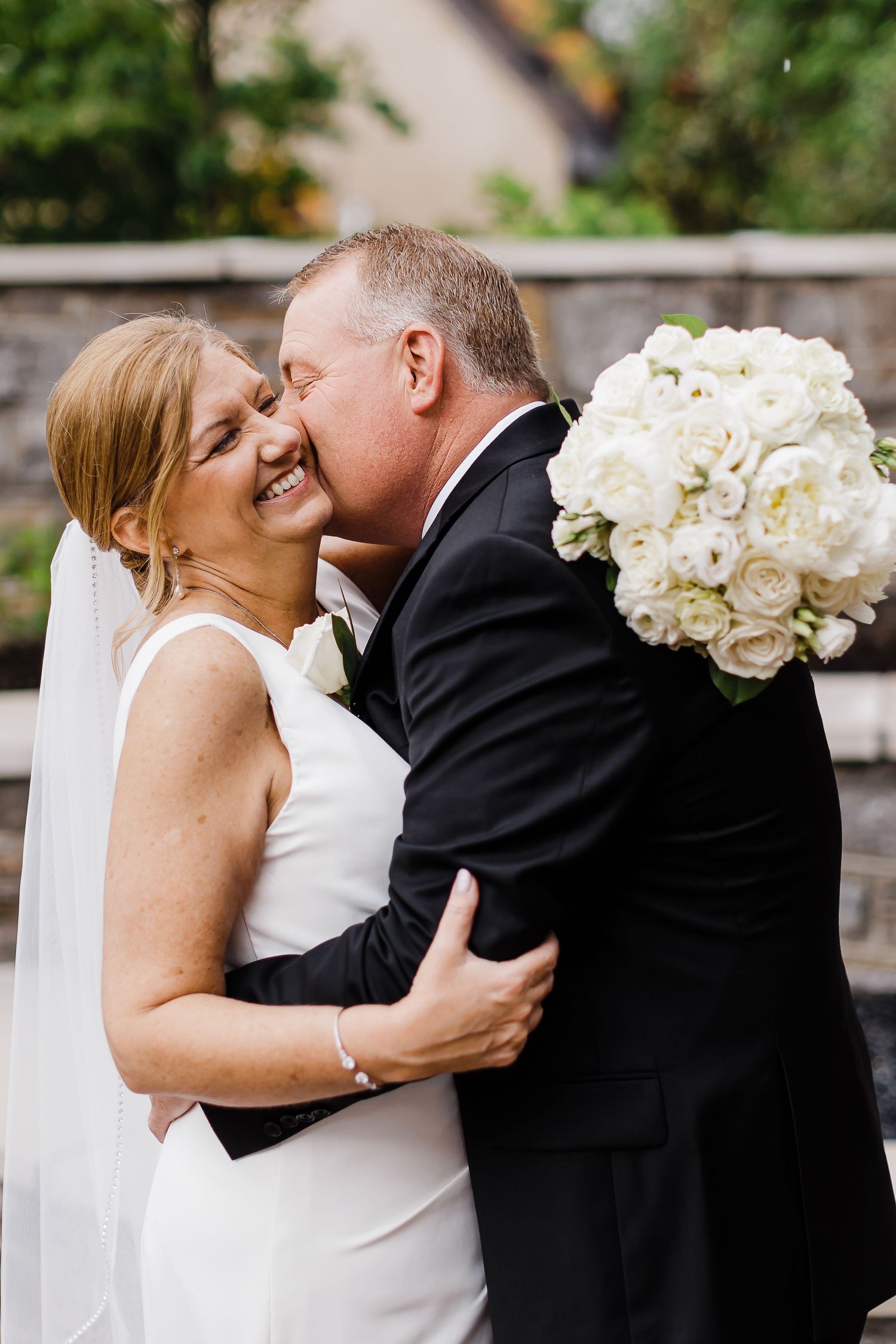Intimate wedding portraits showing tender moments between newlyweds with white rose bouquet.