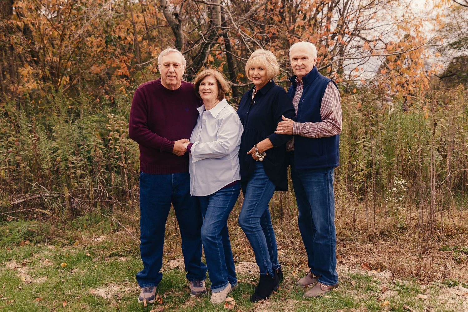 Group of people posing together outdoors during autumn season.