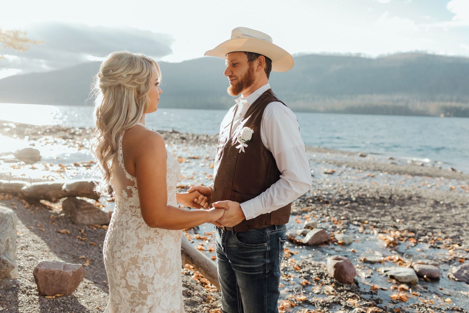 A couple sharing a tender moment during their wedding photoshoot by a scenic lake.
