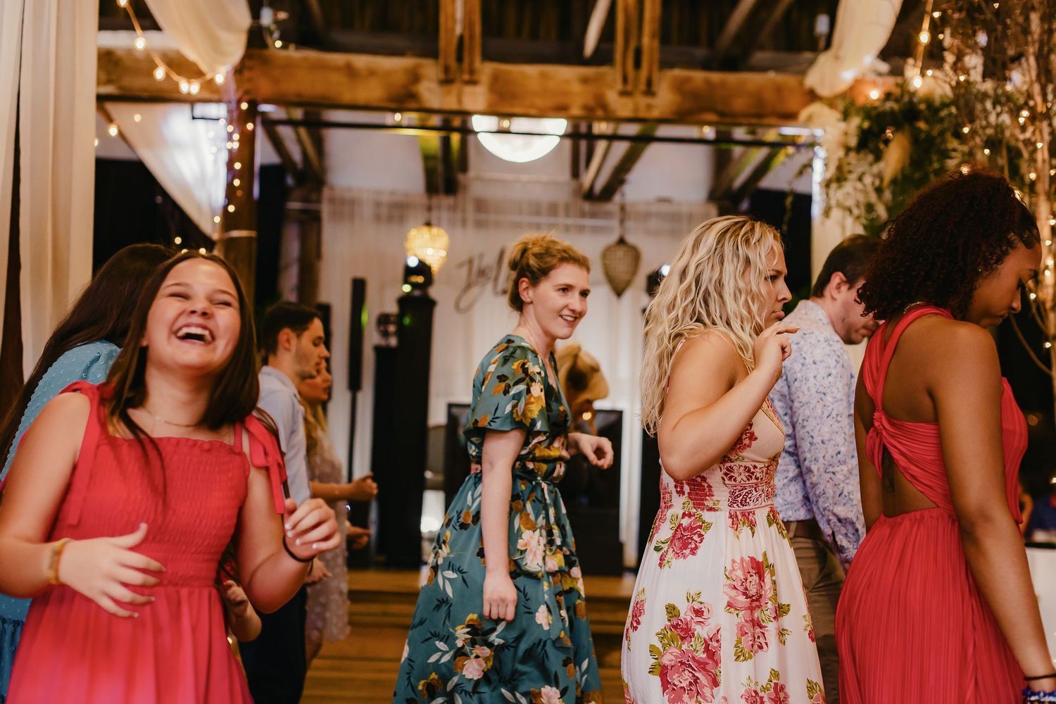 Wedding guests dance and celebrate together on a festively lit dance floor during an evening reception.