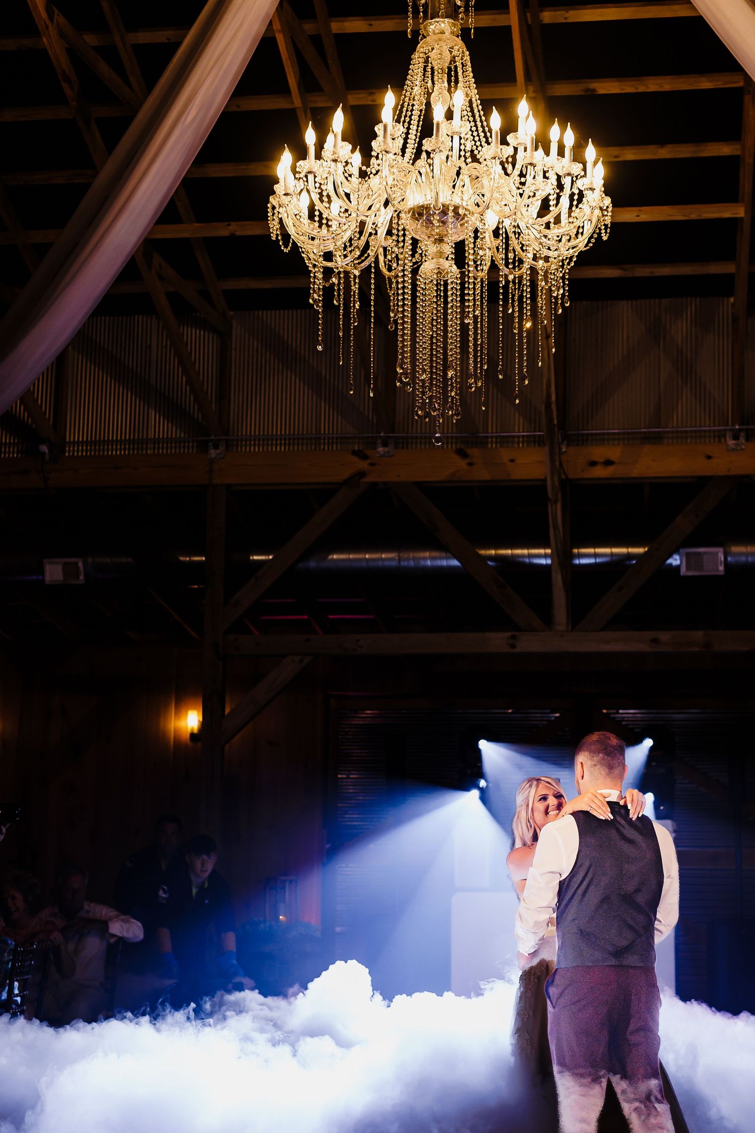First dance under a crystal chandelier with dramatic fog and lighting effects.