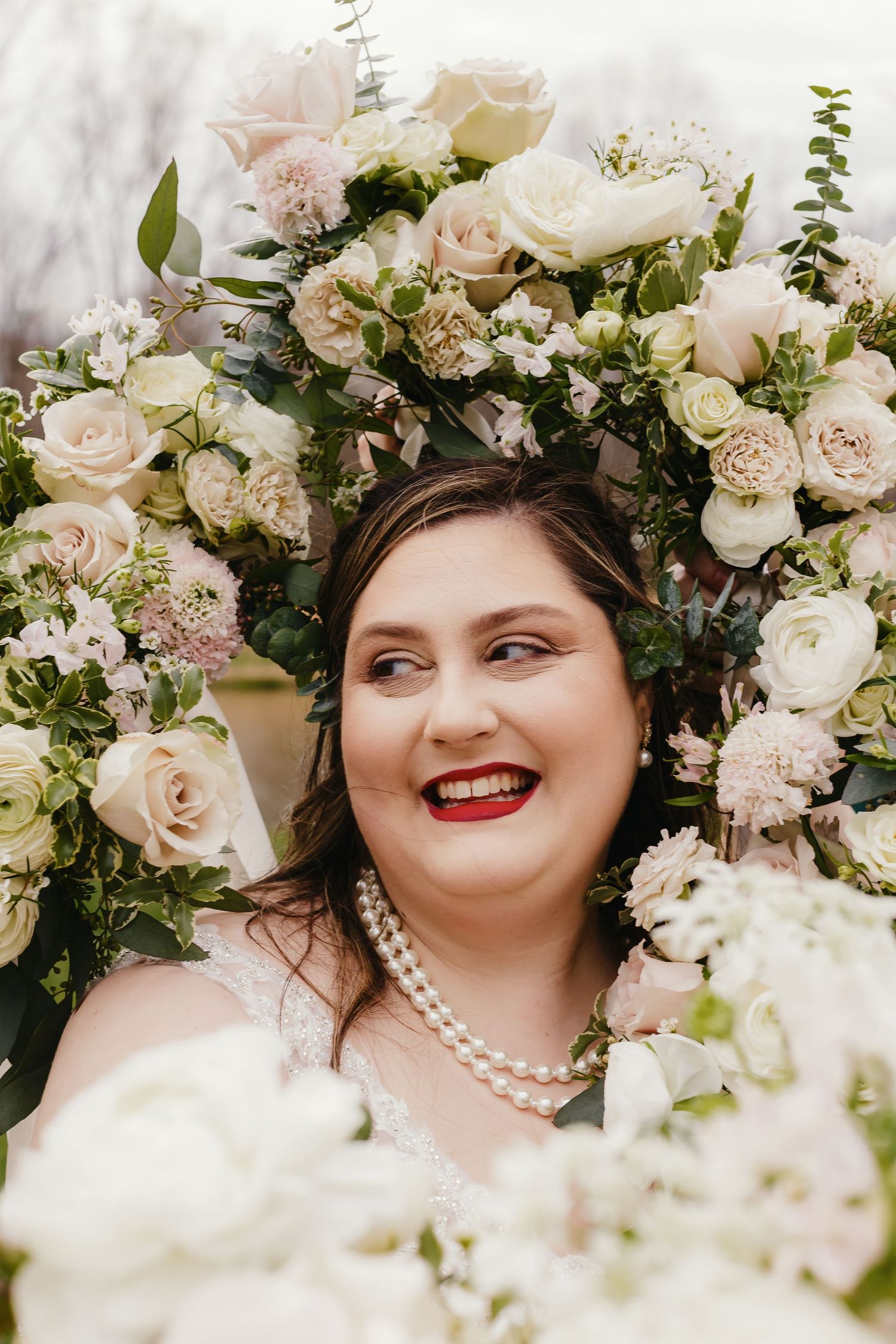 Elegant floral arrangement with white roses and pearls creates a romantic wedding backdrop.