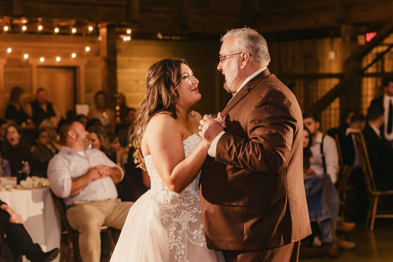 Wedding guests celebrate with sparklers during an evening reception creating magical light trails.