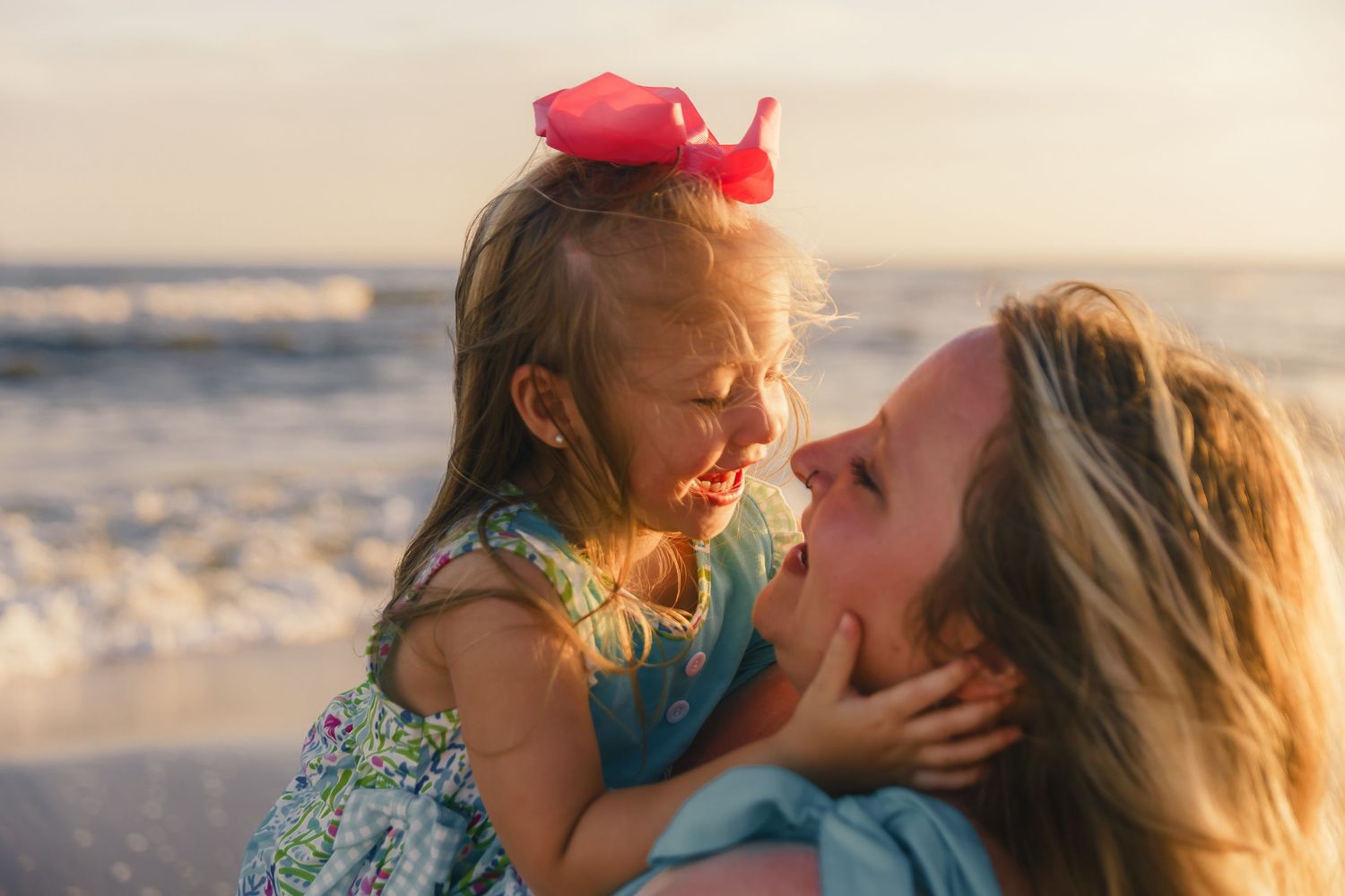 Mother and daughter share joyful moment together on sunny beach.