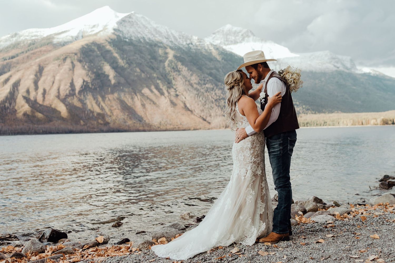 A scenic mountain lake provides the backdrop for an intimate wedding photo session.