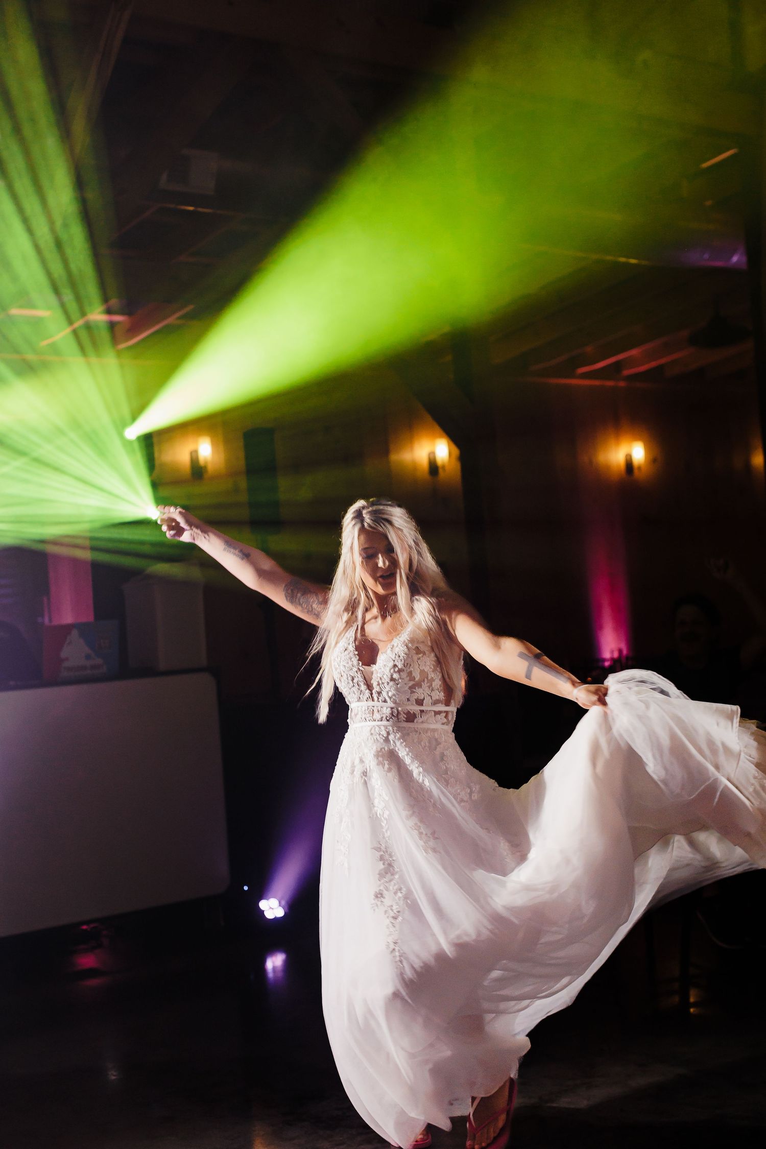Dramatic dance scene with green spotlights illuminating a flowing white dress in motion.