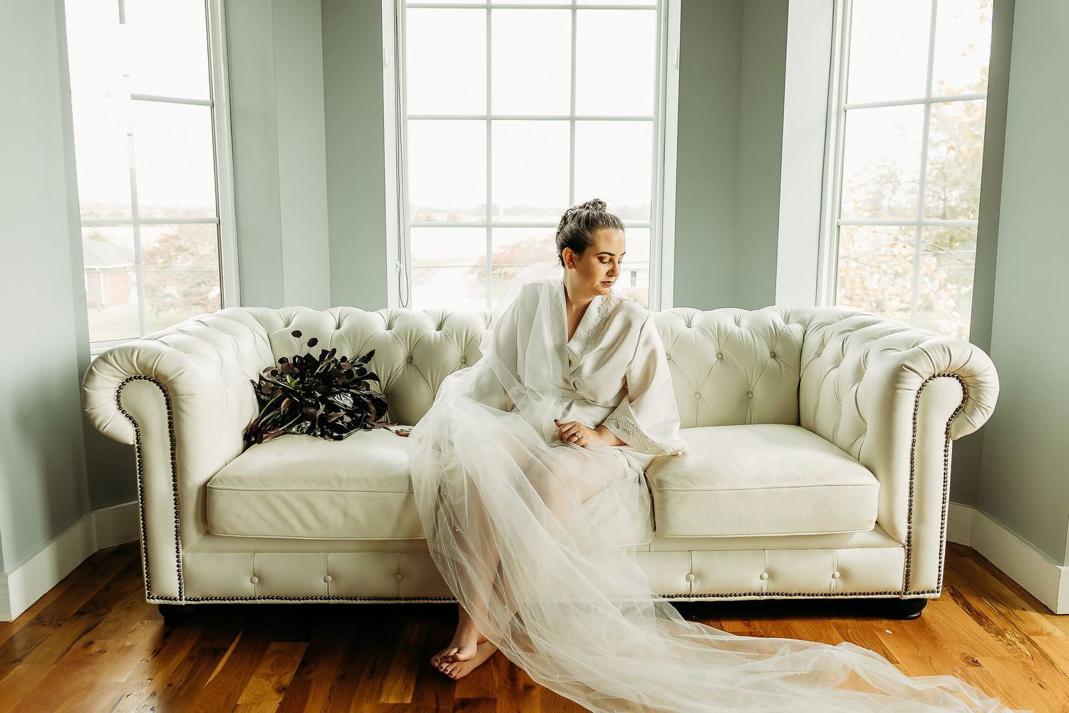 Bridal portraits in a bright white room with large windows.