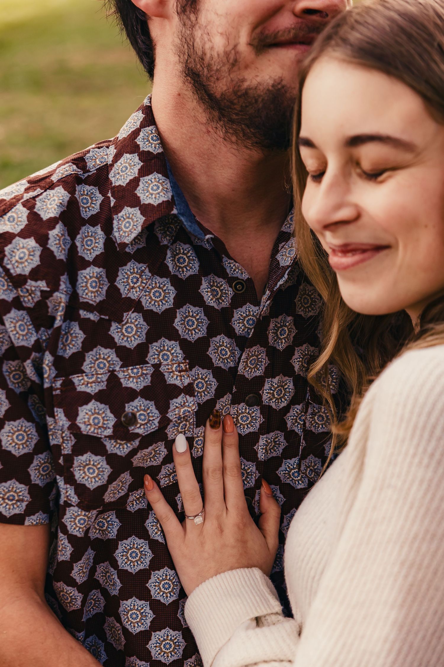 Intimate close-up portraits of a couple sharing tender moments in a patterned shirt and cream sweater.