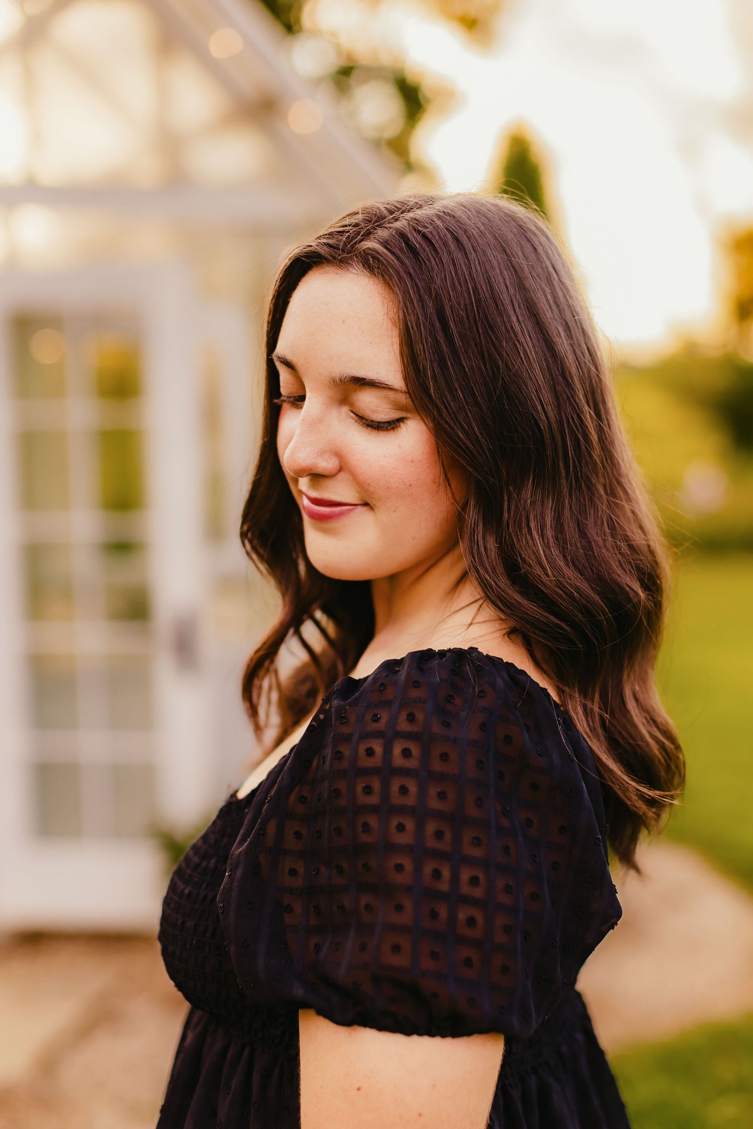 Elegant outdoor portraits featuring a black lace dress against a white building backdrop.