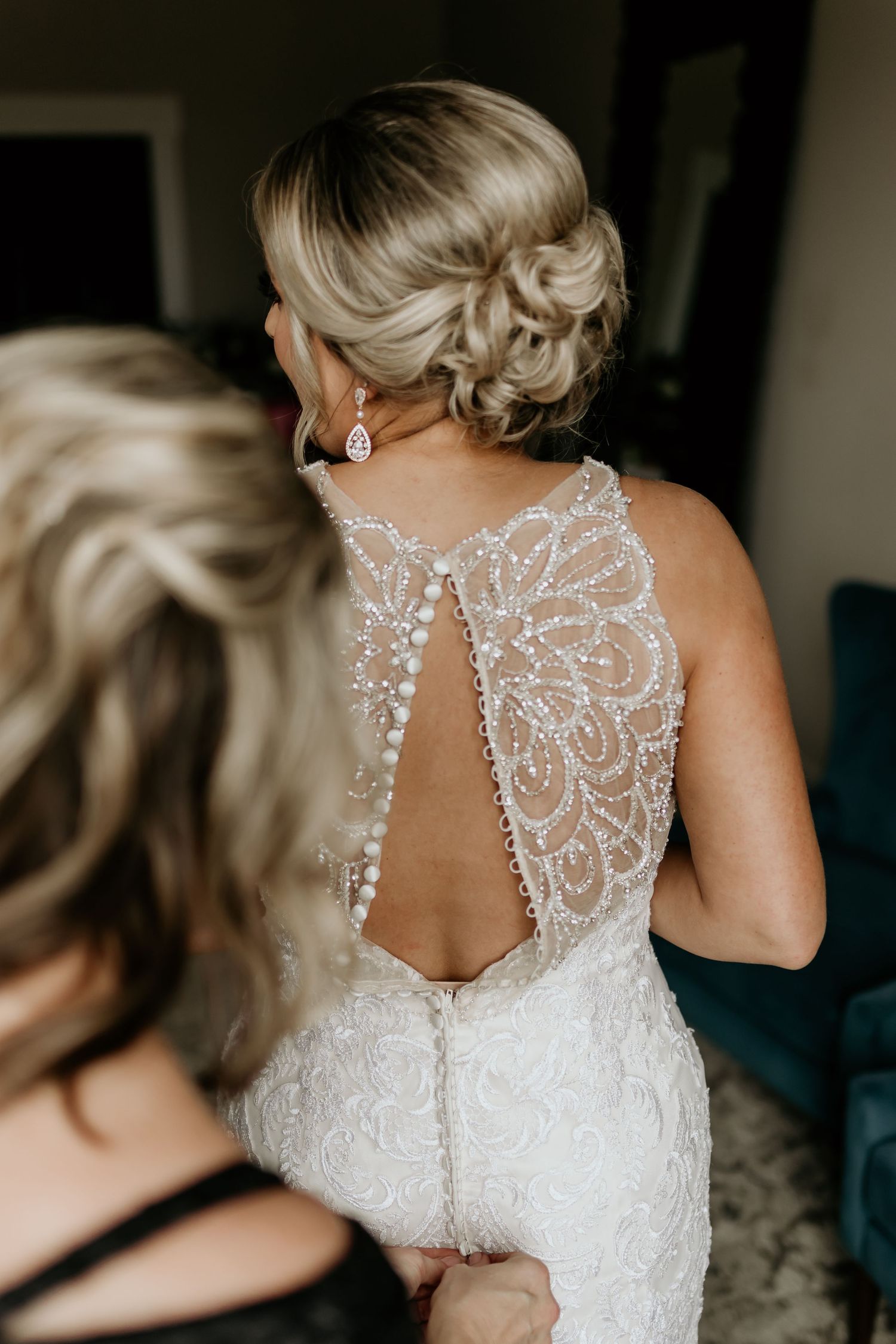Close up view of intricate lace and beadwork details on back of white wedding dress.