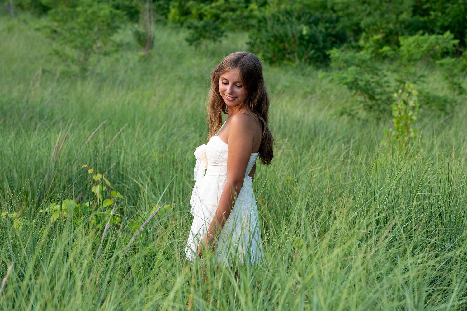 Natural outdoor portrait in green summer meadow with soft lighting.