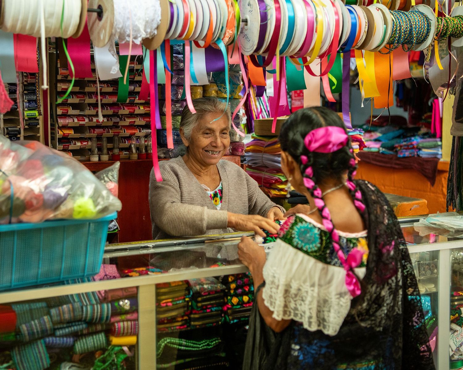 Vibrant display of colorful textiles and handicrafts at a traditional market stall.