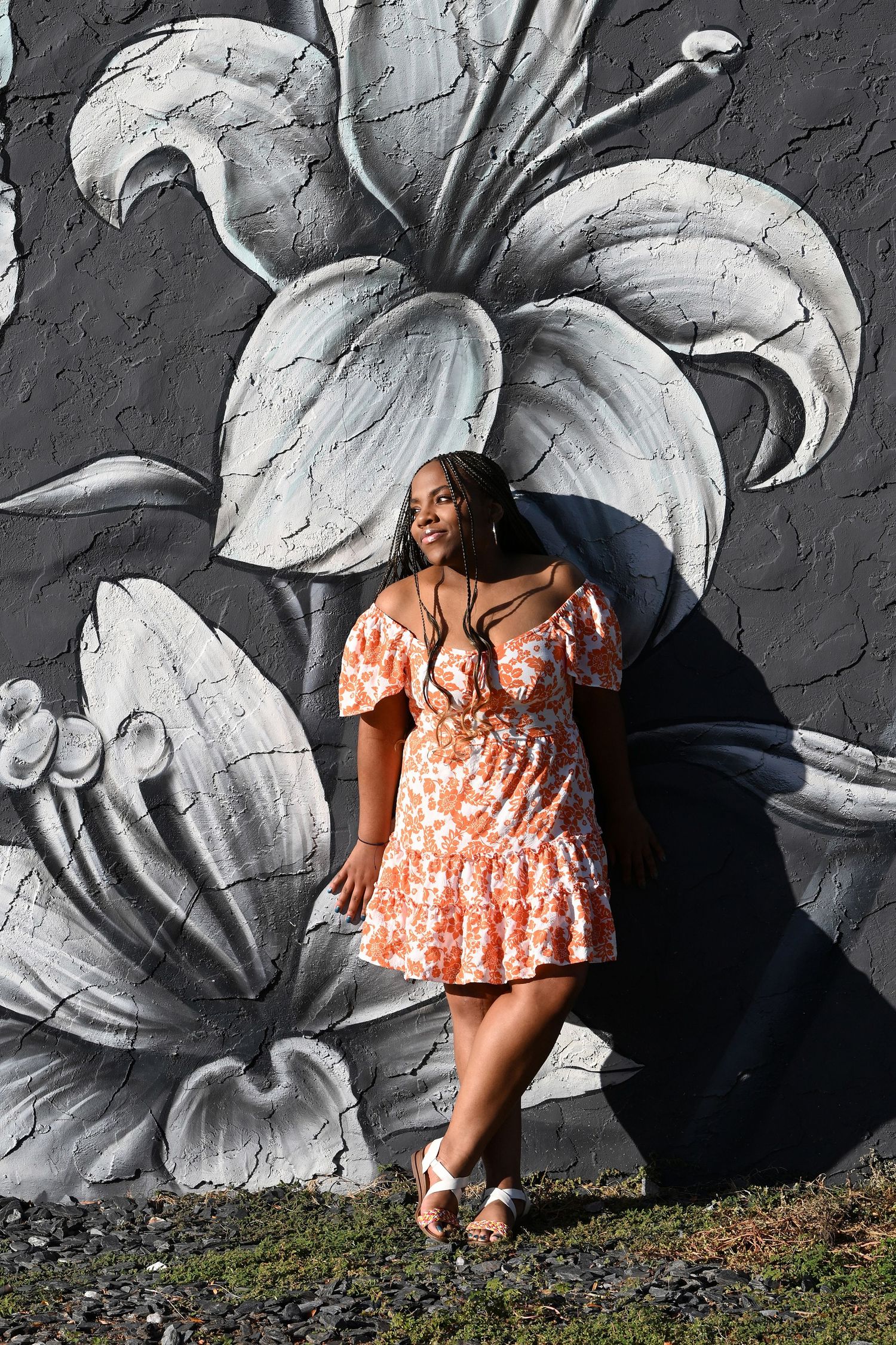 Orange floral dress contrasts beautifully with large monochrome lily wall art.