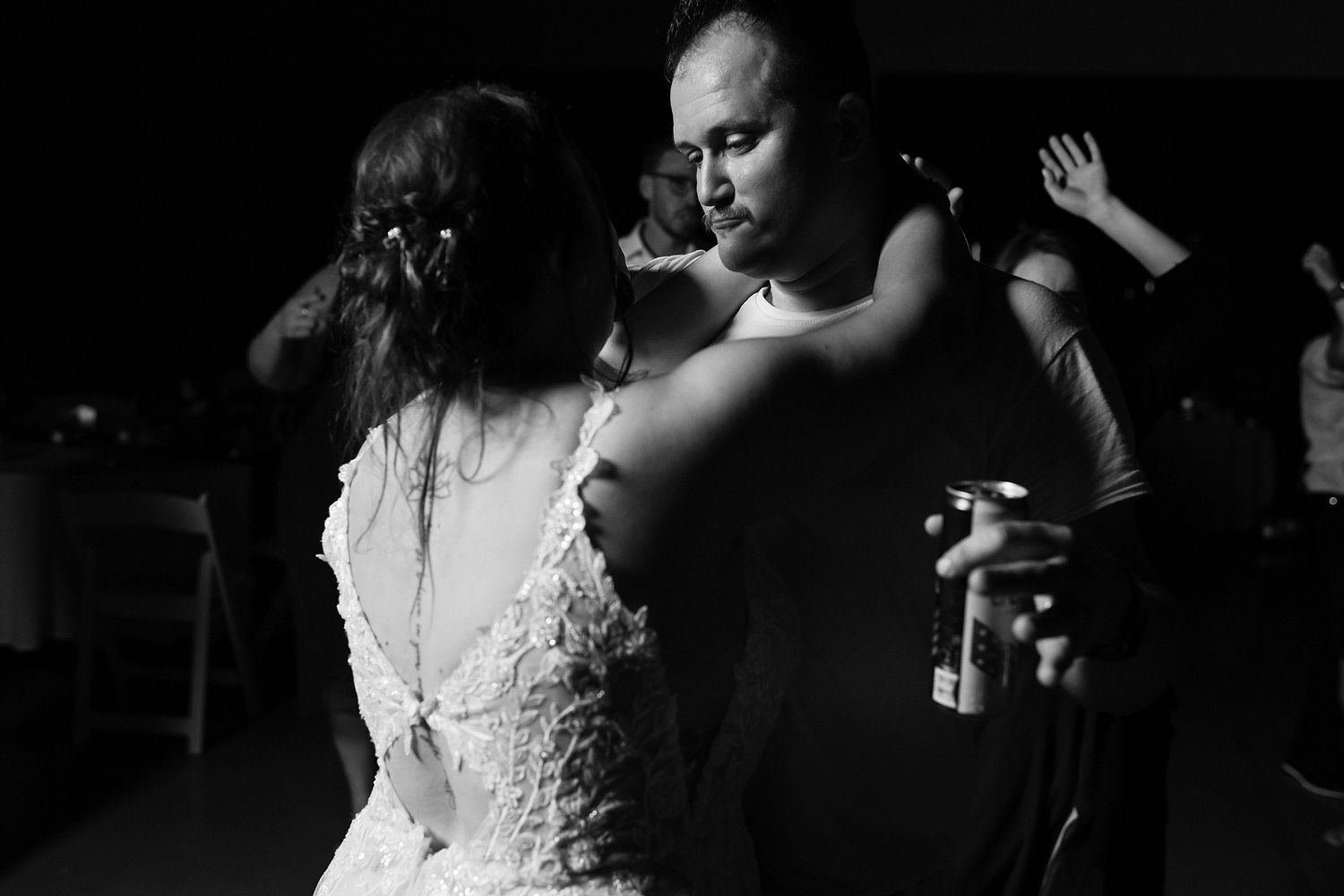 Black and white photo of a bride and groom sharing an intimate dance at their wedding reception.