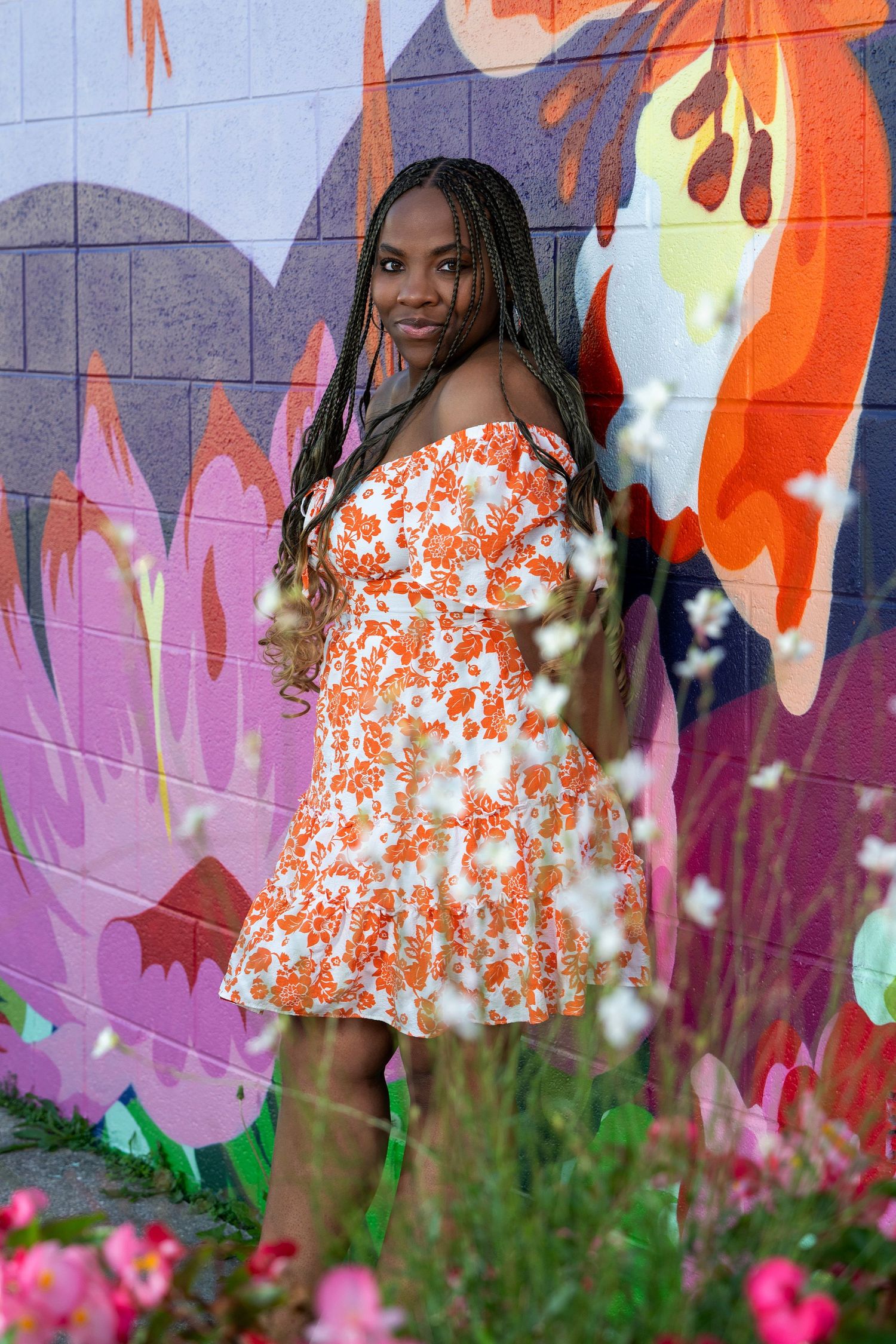 A bright floral-themed outdoor portrait session with pink cosmos flowers in the foreground.