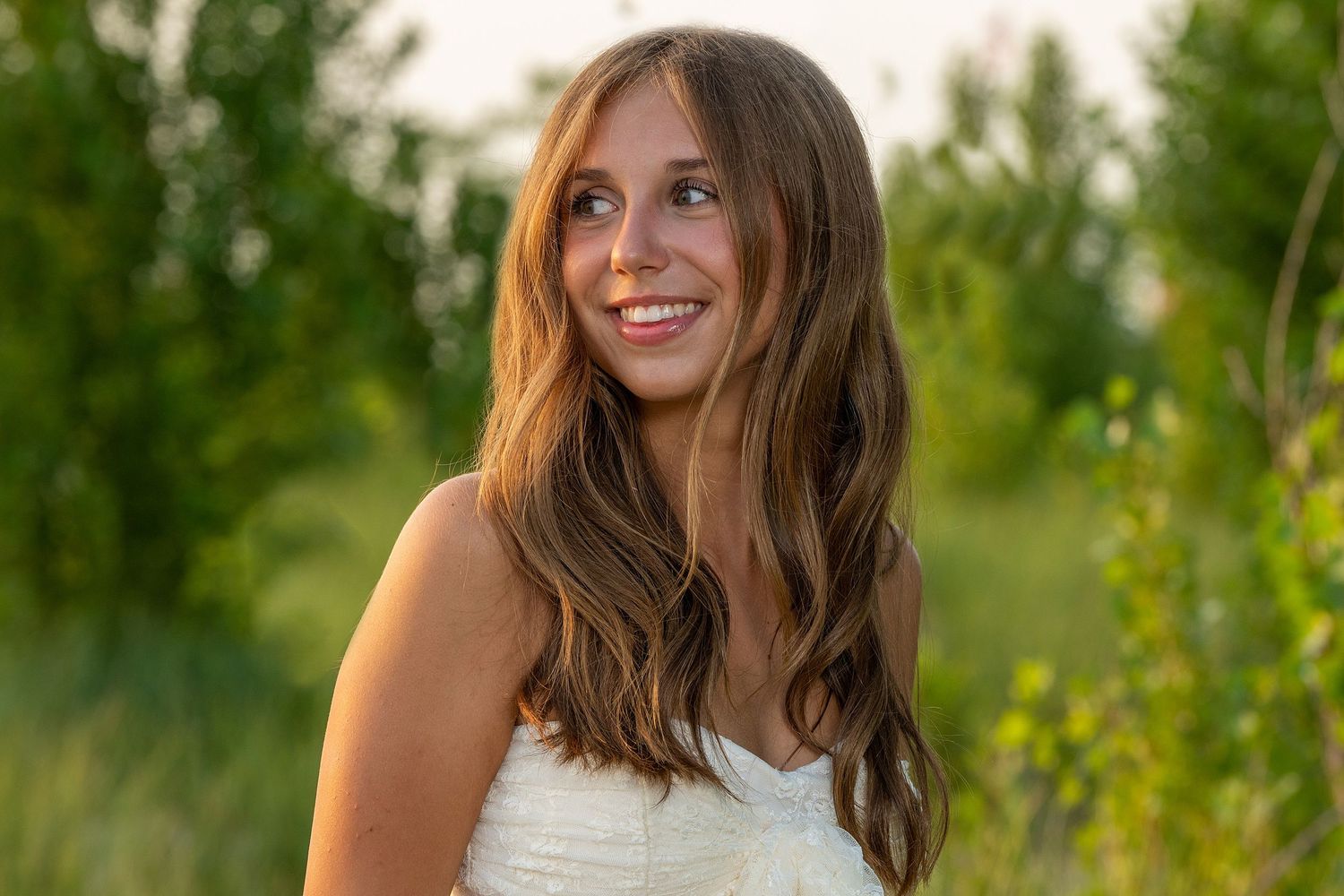 Summer portrait session in golden sunlight among green foliage.